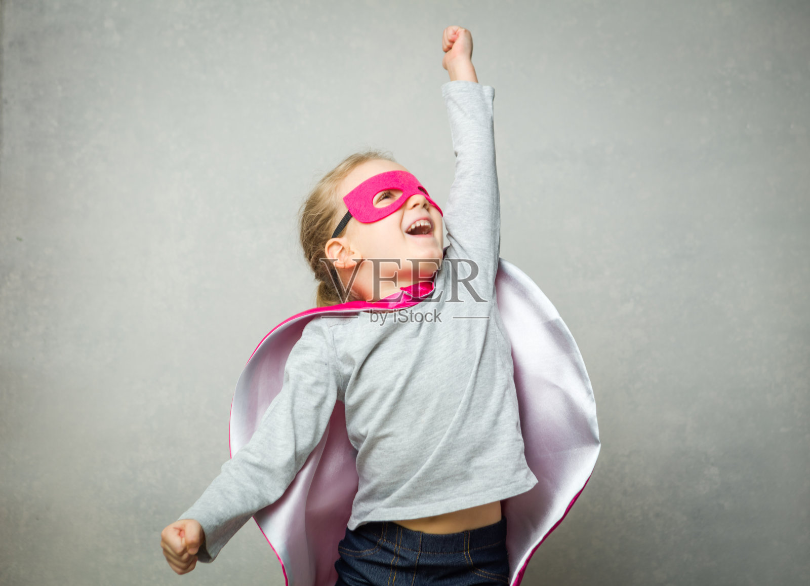 小女孩戴着斗篷和面具假装在飞照片摄影图片