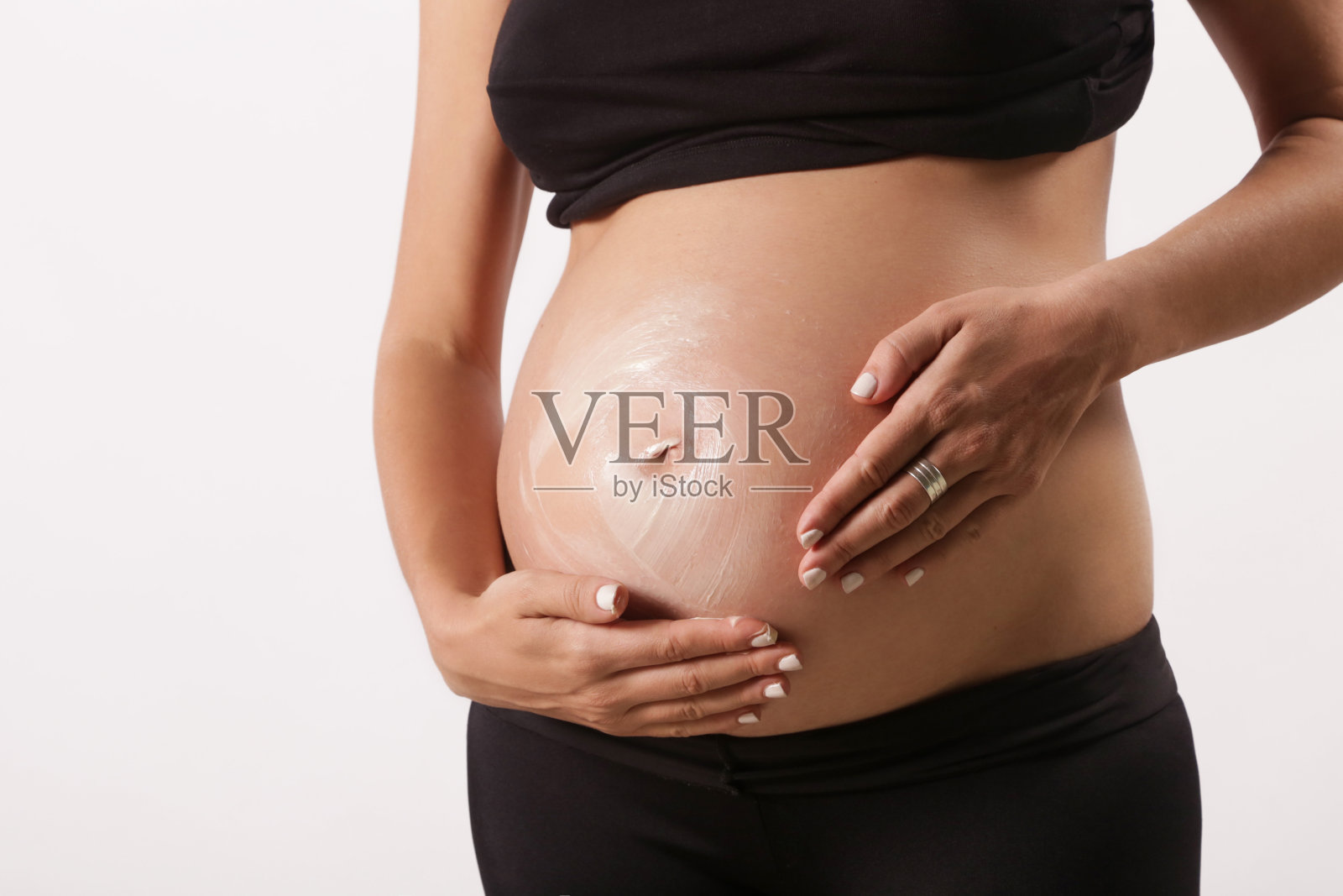孕妇在腹部涂抹保湿霜，防止妊娠纹照片摄影图片