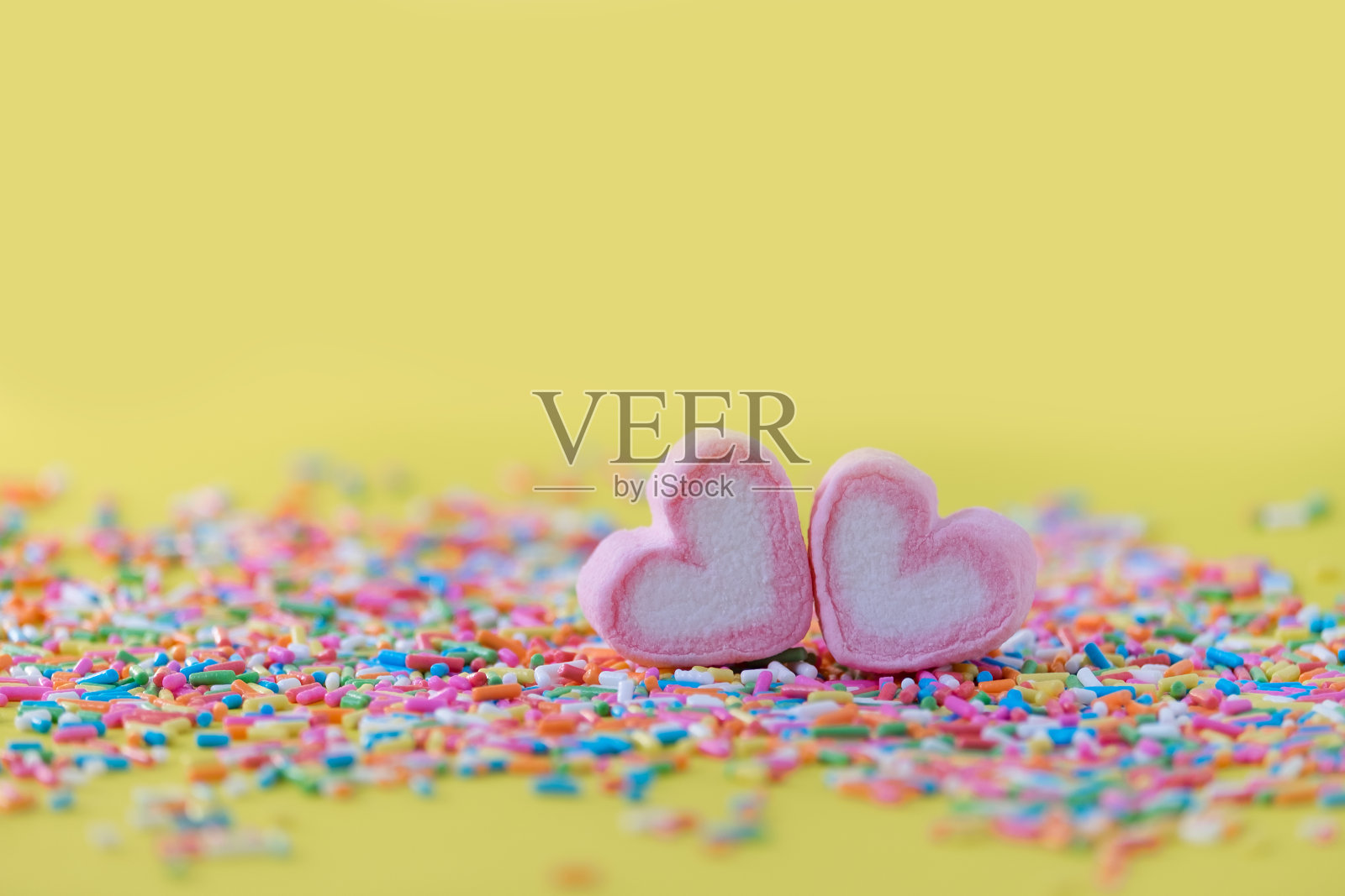 心形的粉红色棉花糖，点缀在绿色的背景和复制空间。情人节爱情庆祝的概念。照片摄影图片
