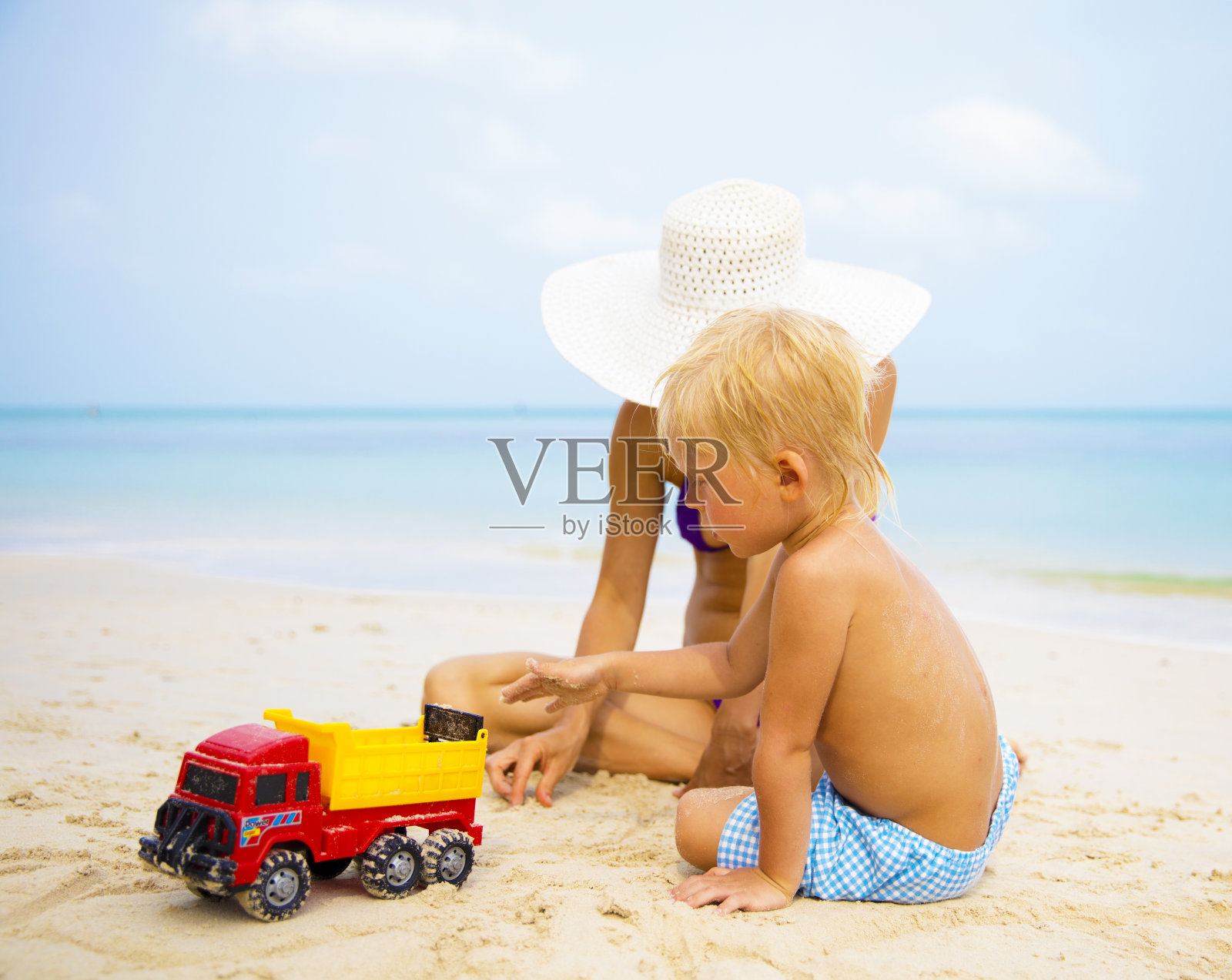小男孩和妈妈在热带海滩照片摄影图片