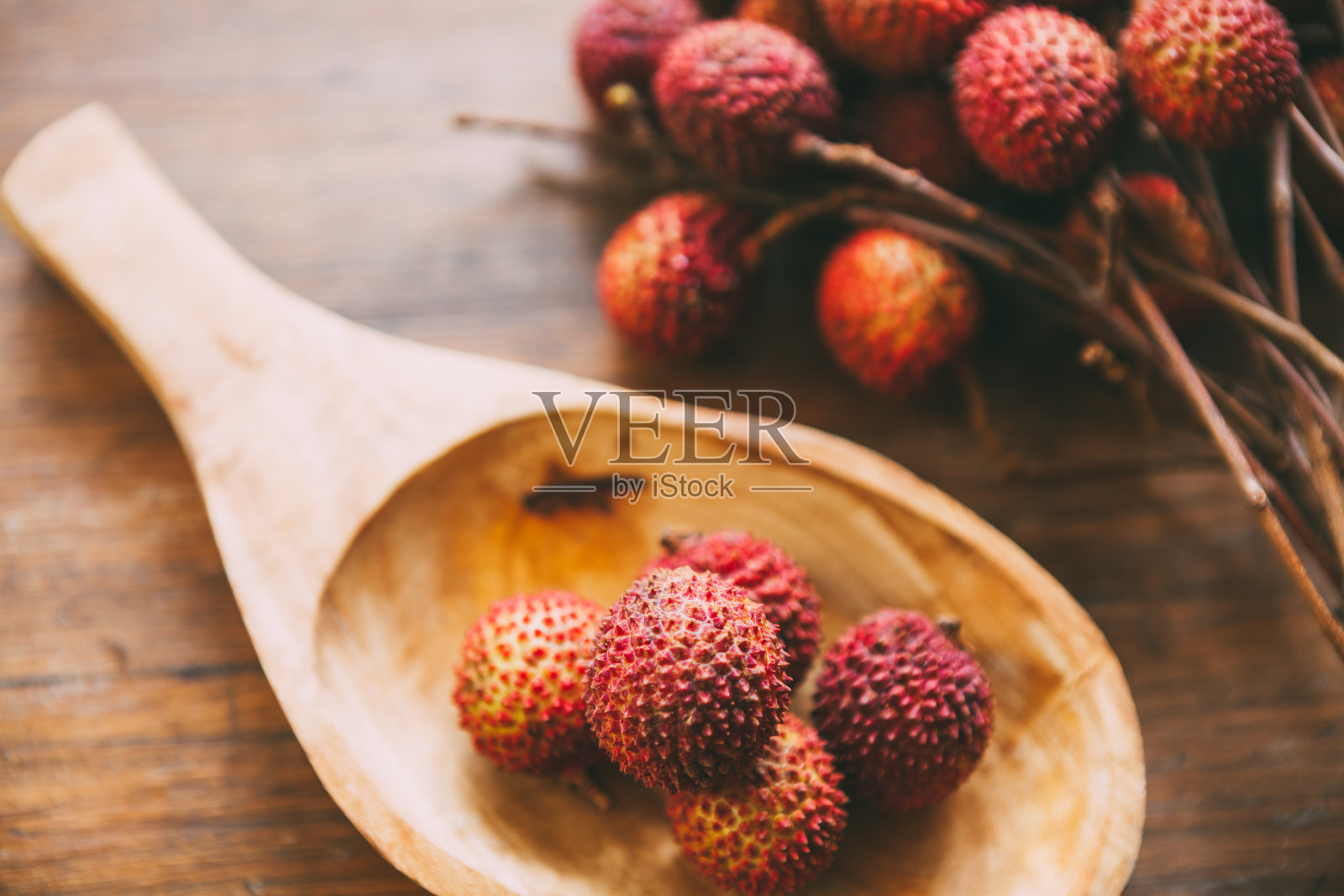 一堆荔枝放在木勺上。新鲜健康的水果。食品的背景照片摄影图片