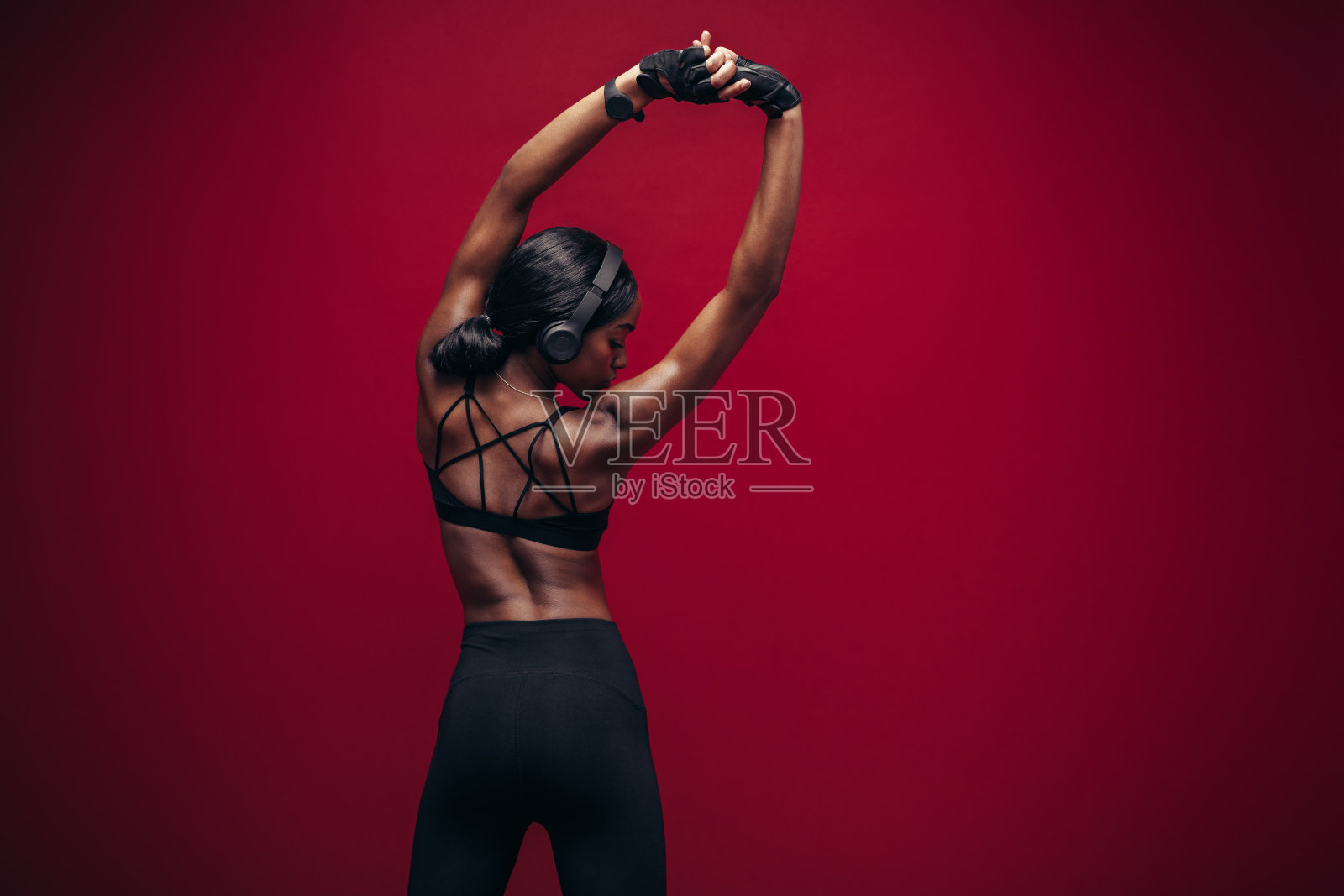 戴着耳机伸直双臂的女运动员照片摄影图片