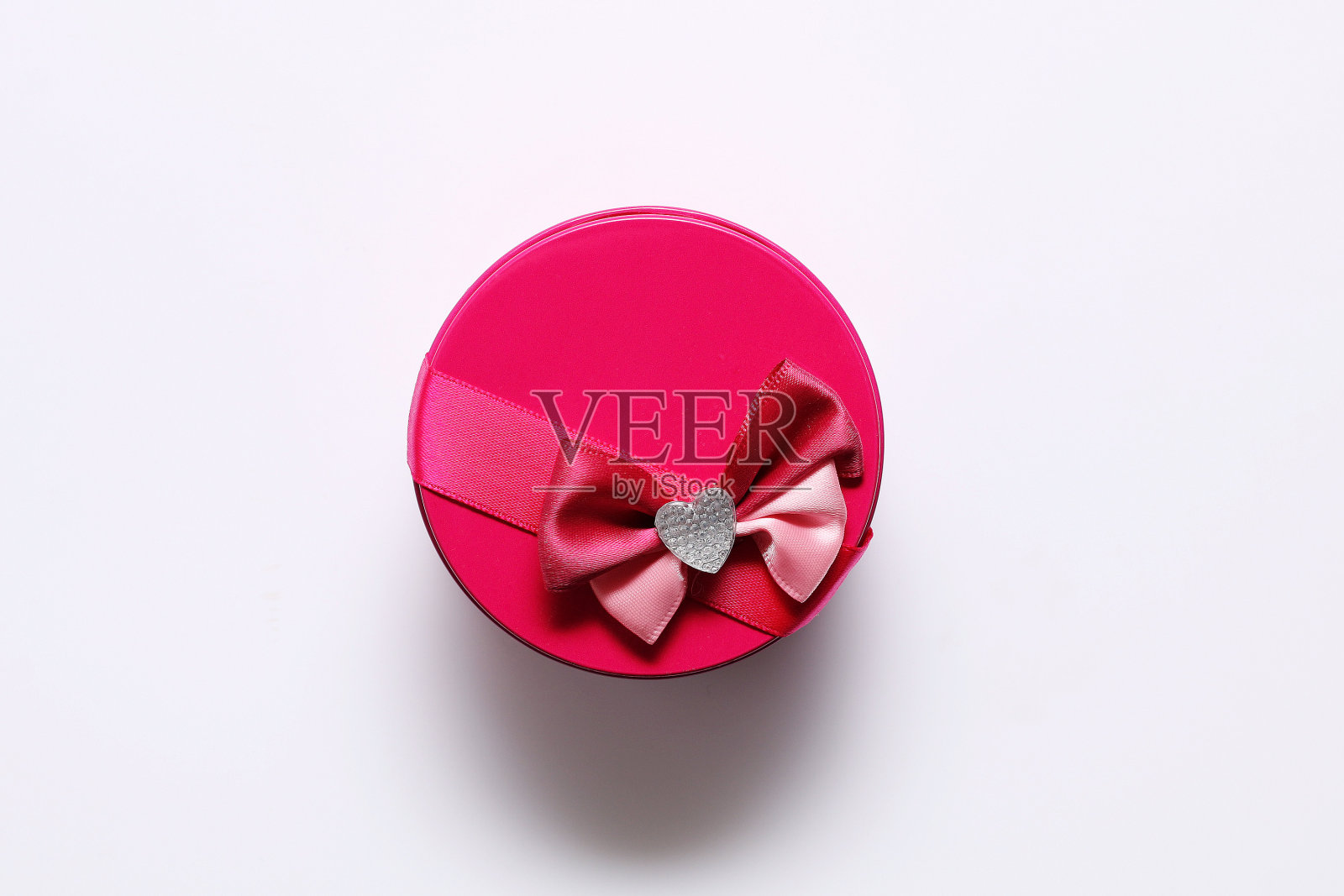 白色背景上带蝴蝶结的粉红色小礼品圆盒照片摄影图片