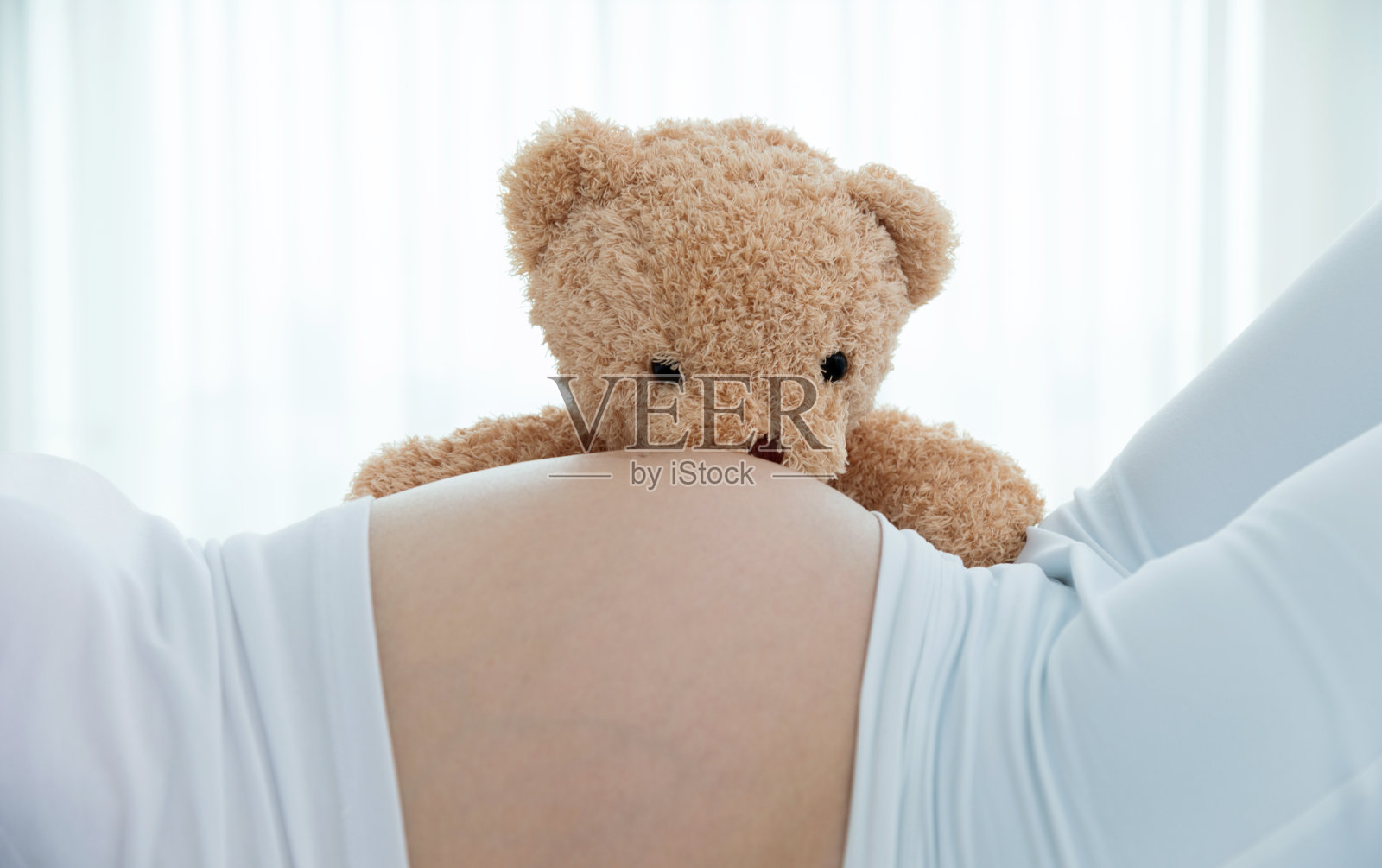 孕妇的肚子和泰迪熊照片摄影图片