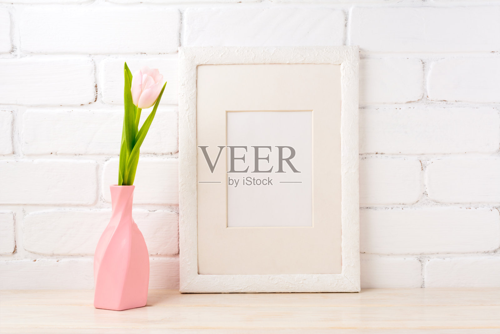 白色框架模型与粉红色郁金香在漩涡花瓶照片摄影图片