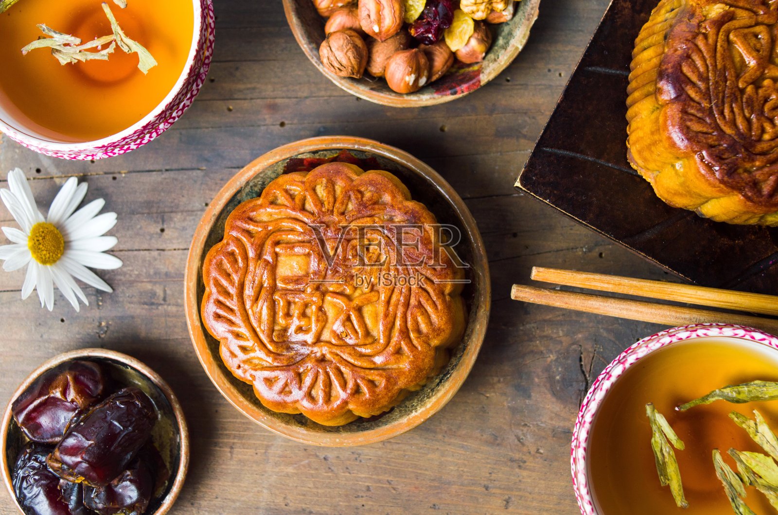 中式月饼配茶、榛子和阿拉伯枣照片摄影图片