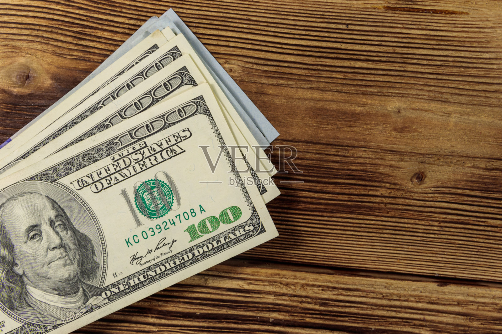 木桌上一叠一百美元钞票照片摄影图片