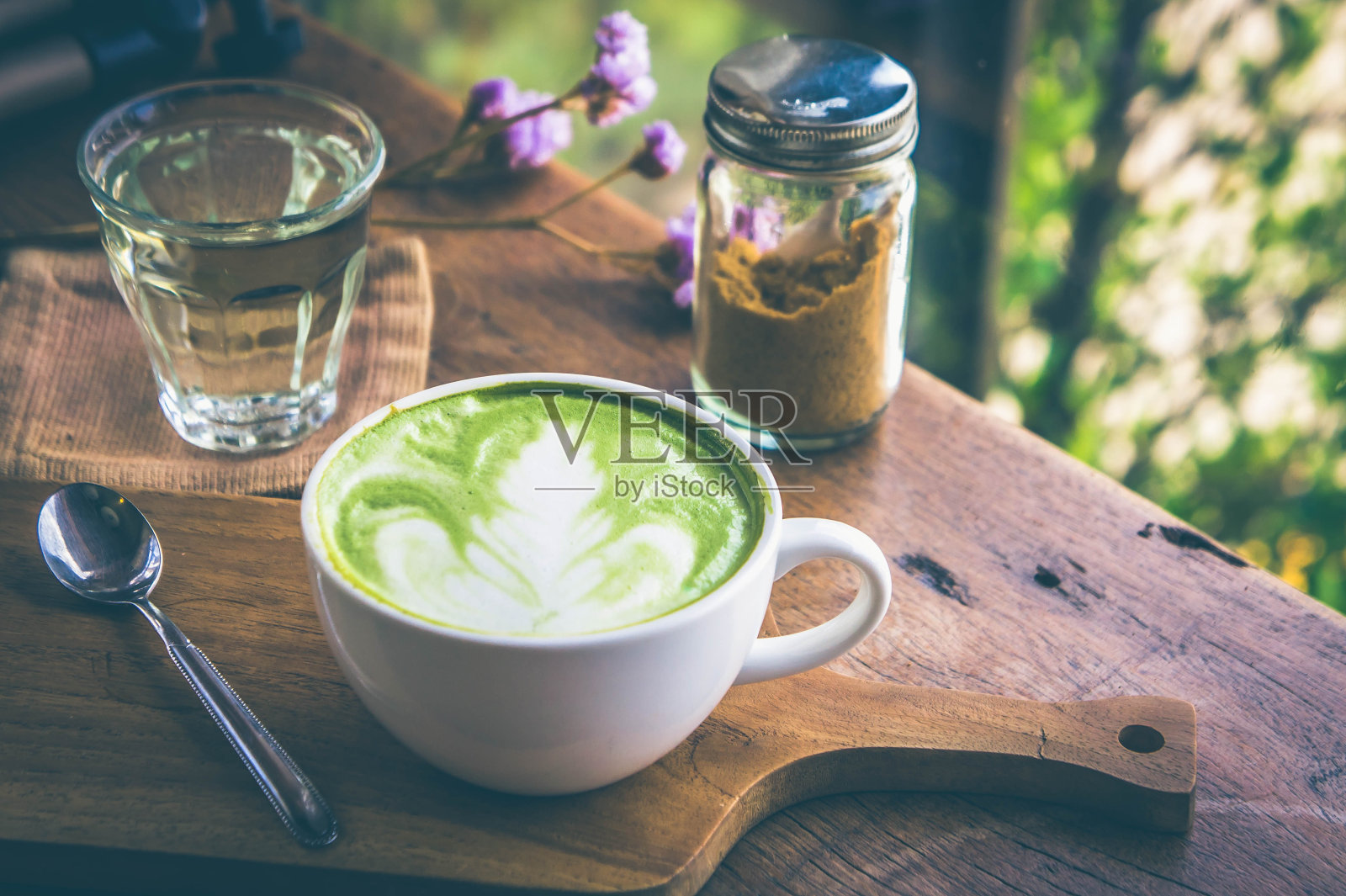 绿茶热饮拿铁白杯放在木桌上，香气馥郁，休闲时光在咖啡厅咖啡厅照片摄影图片