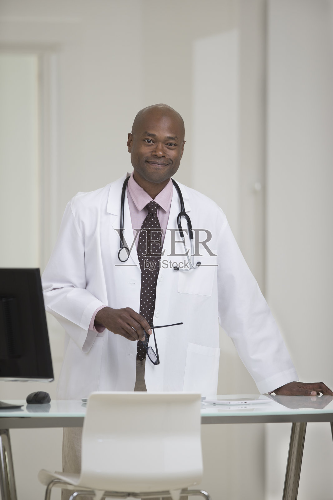 非裔美国医生站在办公桌前照片摄影图片