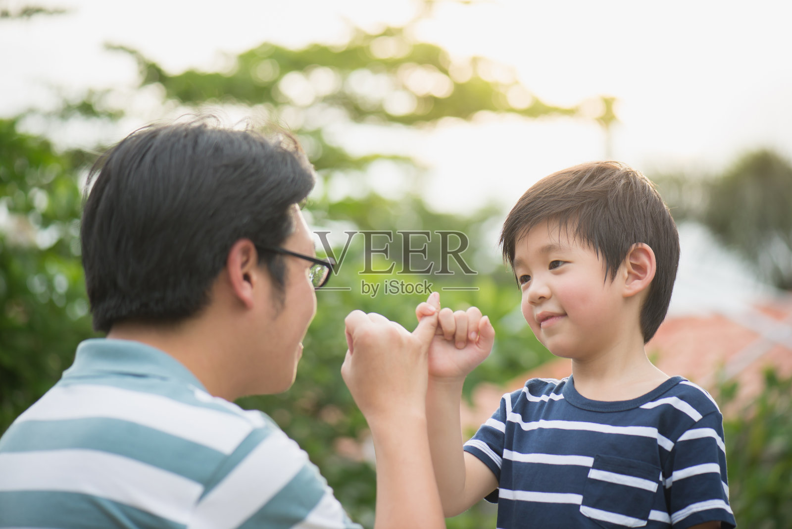 亚裔父亲和他的儿子在做小指承诺照片摄影图片