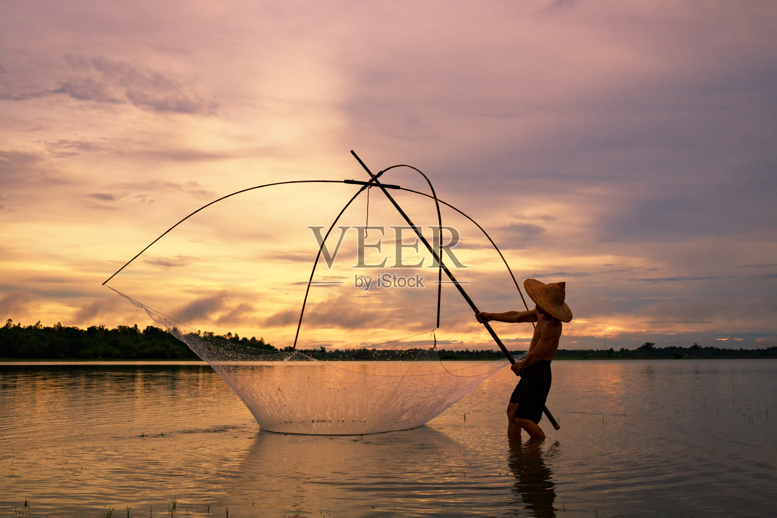 渔民在剪影日出与渔具钓鱼照片摄影图片