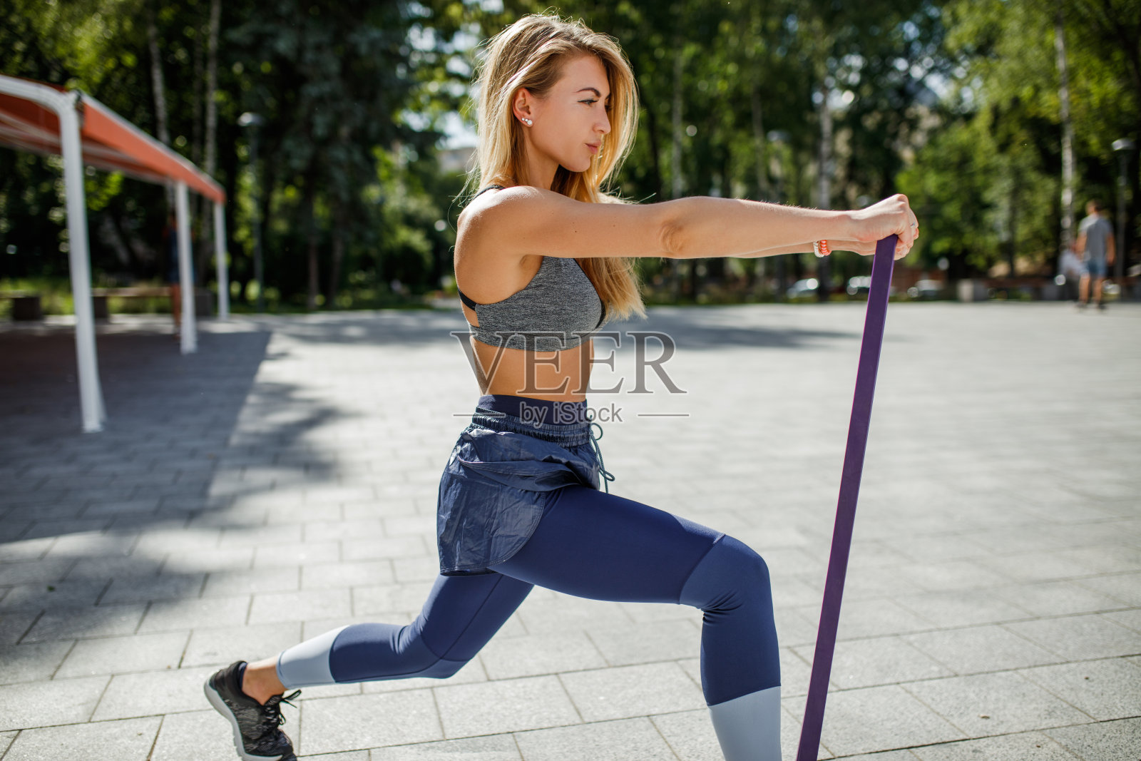 年轻漂亮的女人用橡皮筋健身照片摄影图片