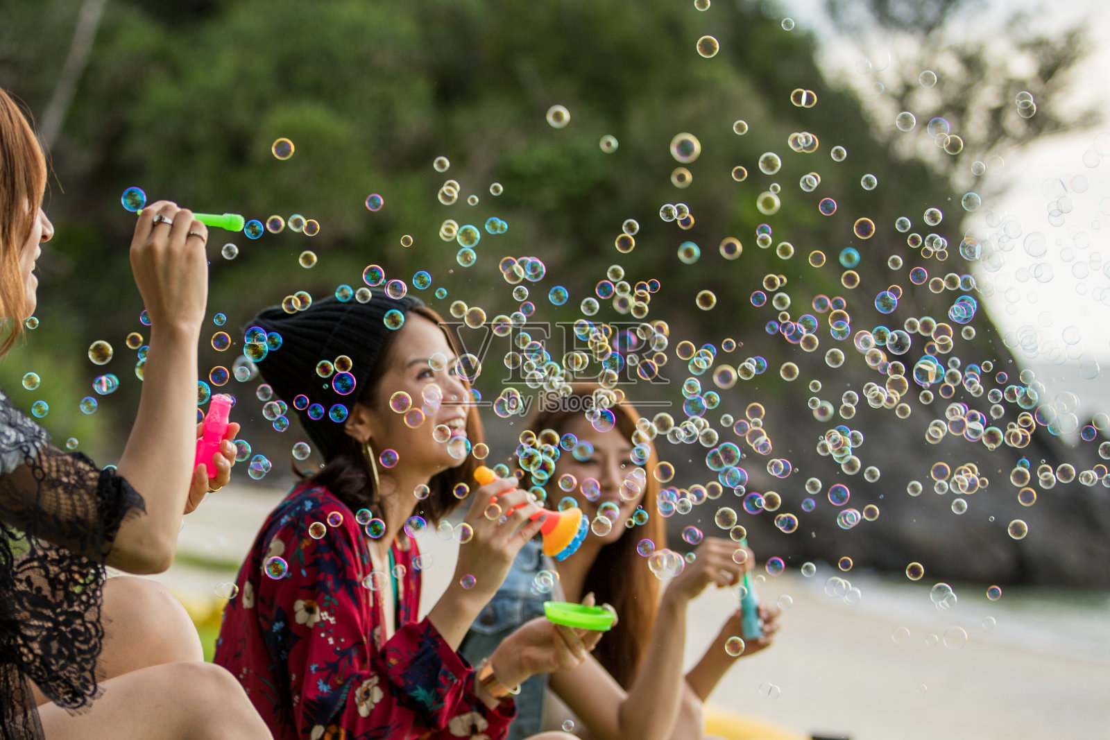 年轻的女性在户外玩和吹泡泡照片摄影图片