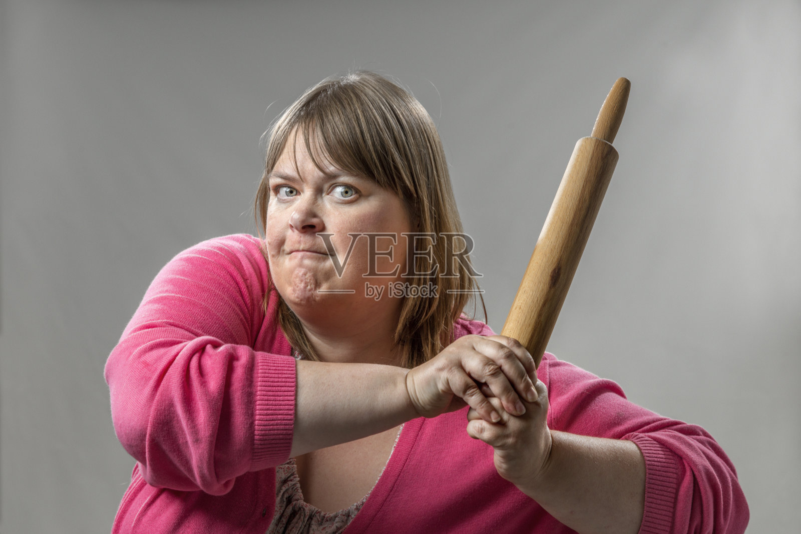 愤怒的女人举着擀面杖照片摄影图片