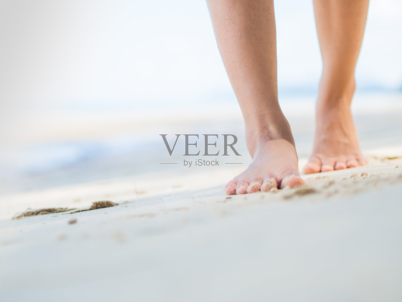 海滩旅行-在沙滩上行走的女人。女性脚的特写细节。step up概念。照片摄影图片