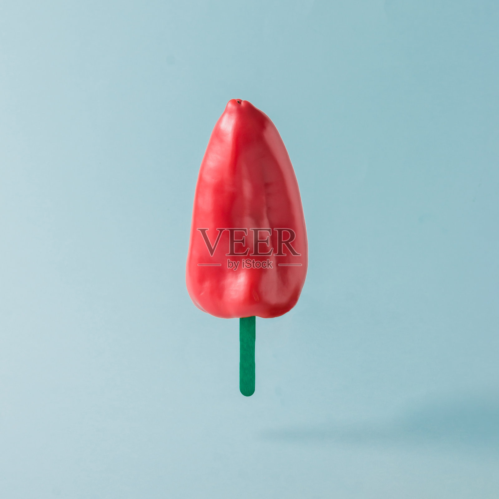 粉蓝色背景上的红辣椒和冰淇淋棒。食品创意概念。照片摄影图片