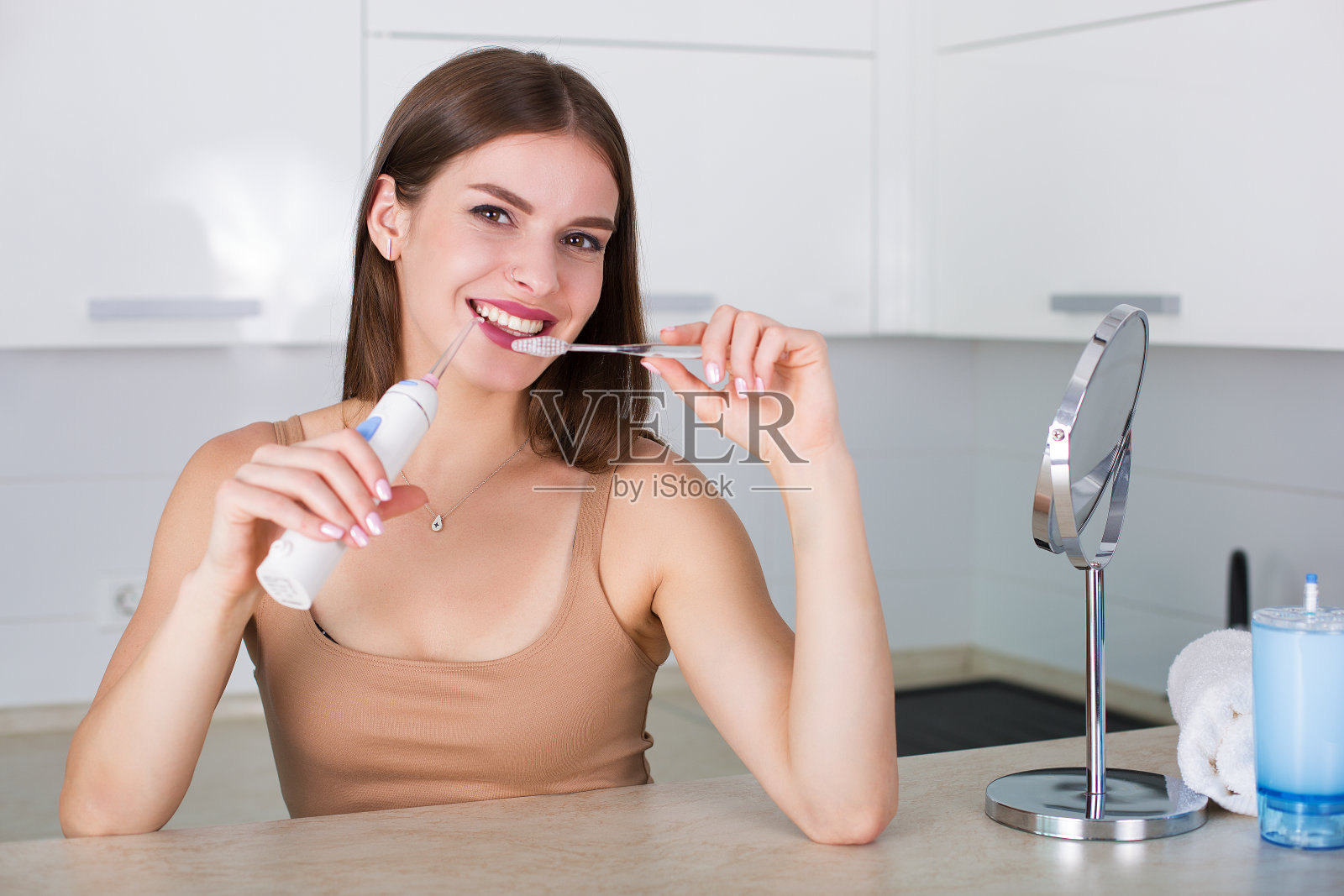有牙刷和口腔冲洗器的女人照片摄影图片