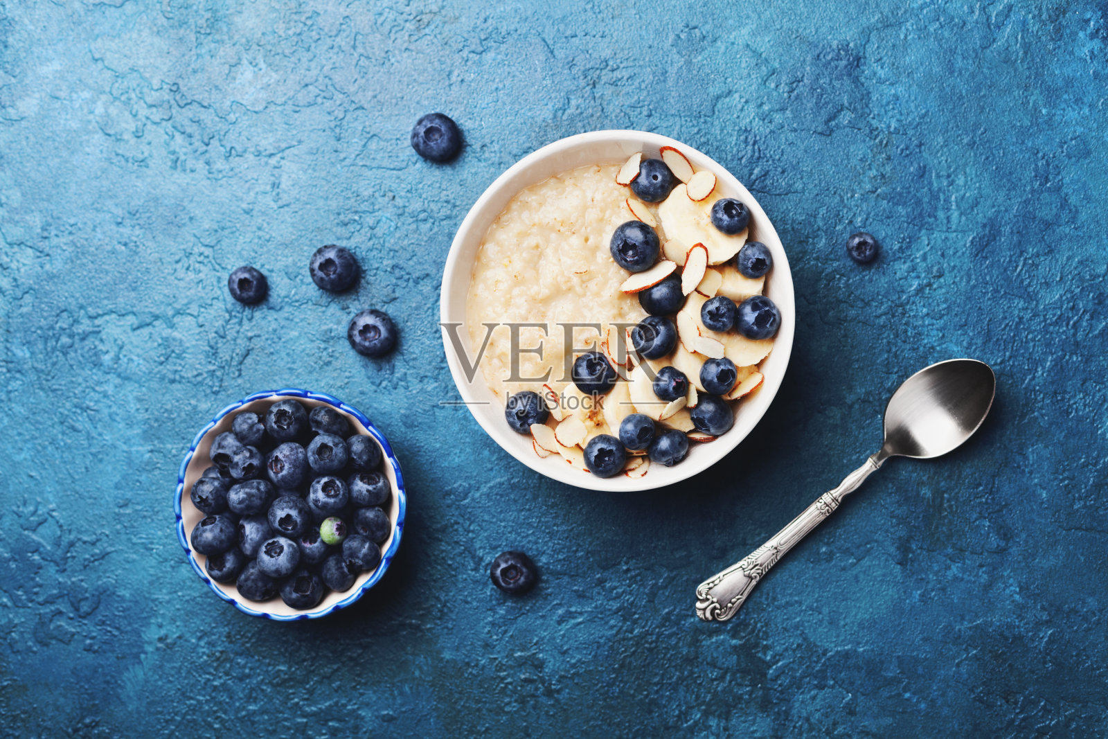 一碗香蕉和蓝莓燕麦粥，放在复古桌面上，平铺风格。自制的早餐。照片摄影图片