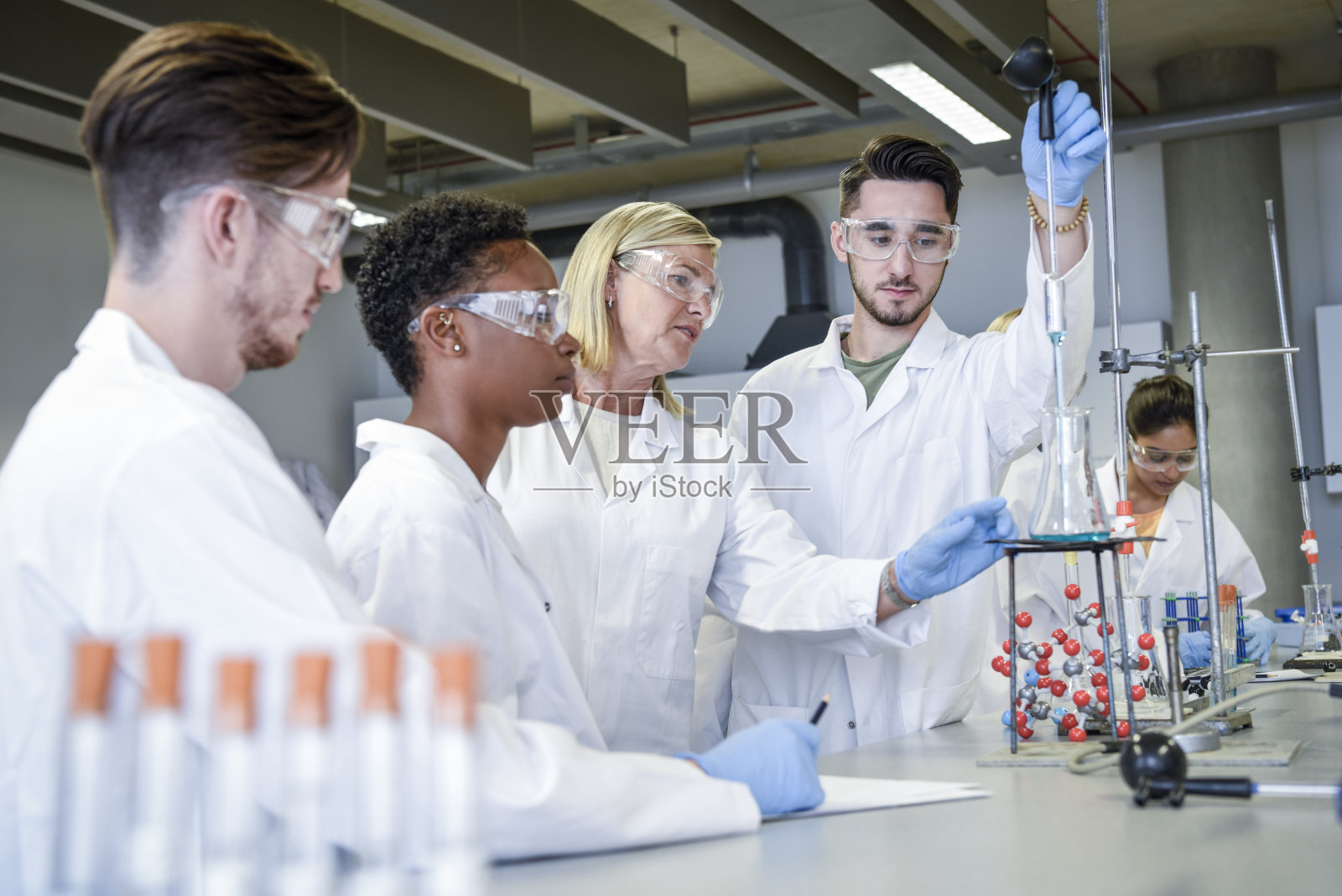 科学教师在实验室教年轻的化学学生照片摄影图片