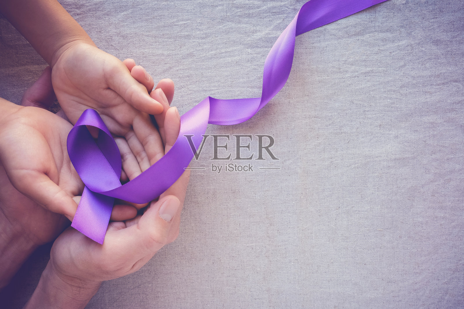 手握紫色丝带，调色复制空间背景，阿尔茨海默病，胰腺癌，癫痫意识，家庭暴力意识照片摄影图片