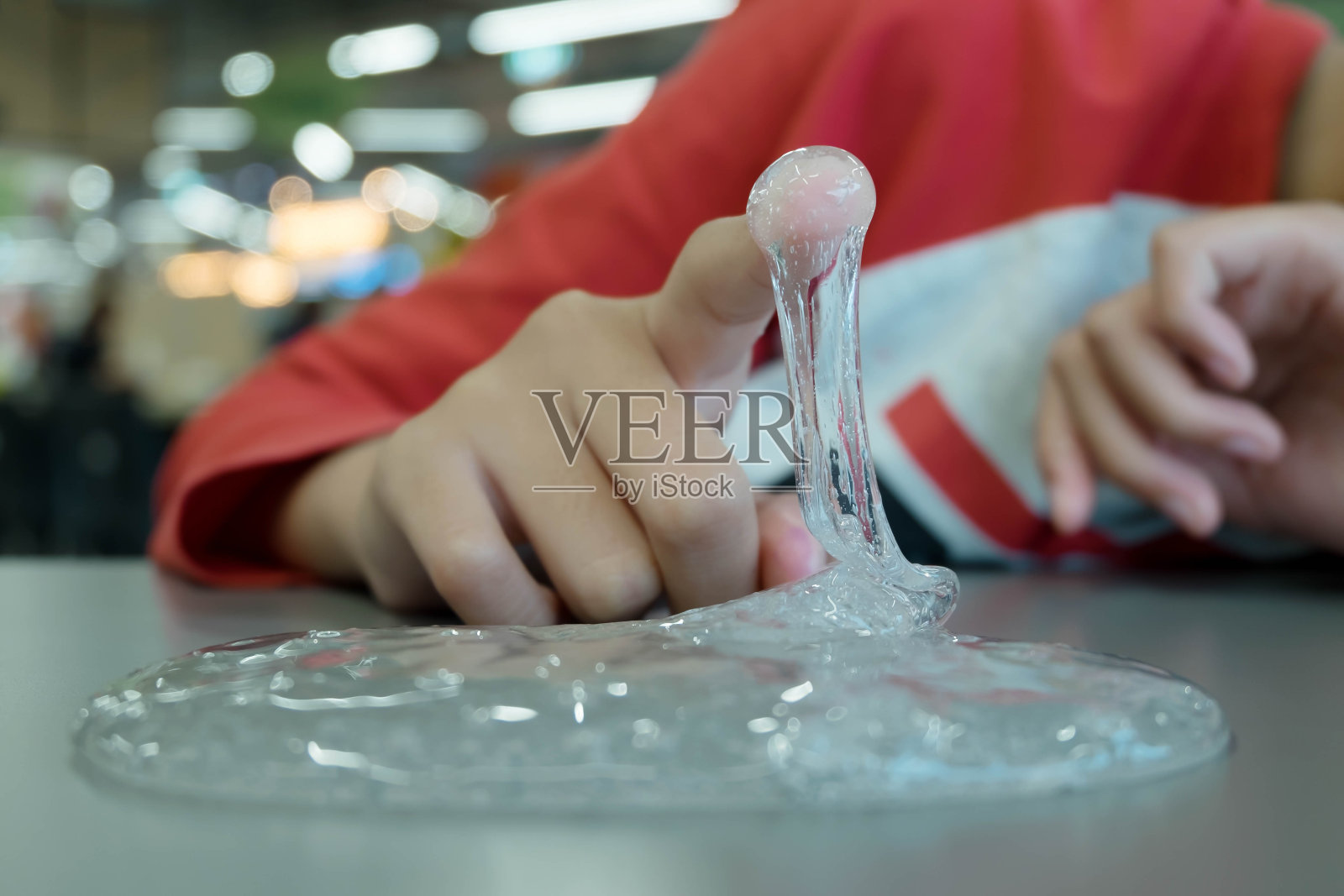 孩子玩手工制作的玩具称为黏液，选择性关注黏液，青少年有乐趣和创造性的自制黏液。照片摄影图片