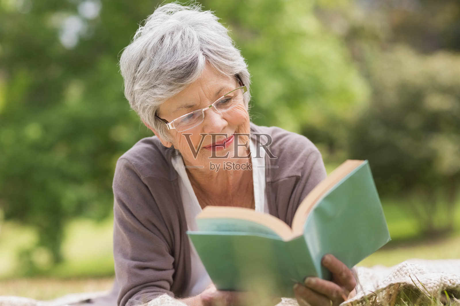 老妇人在公园看书照片摄影图片