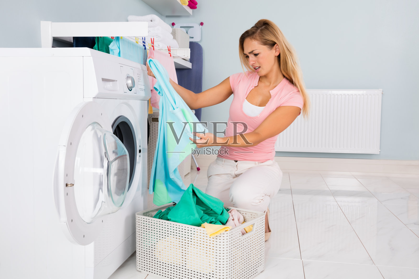 洗完衣服后看着蓝色t恤的女人照片摄影图片