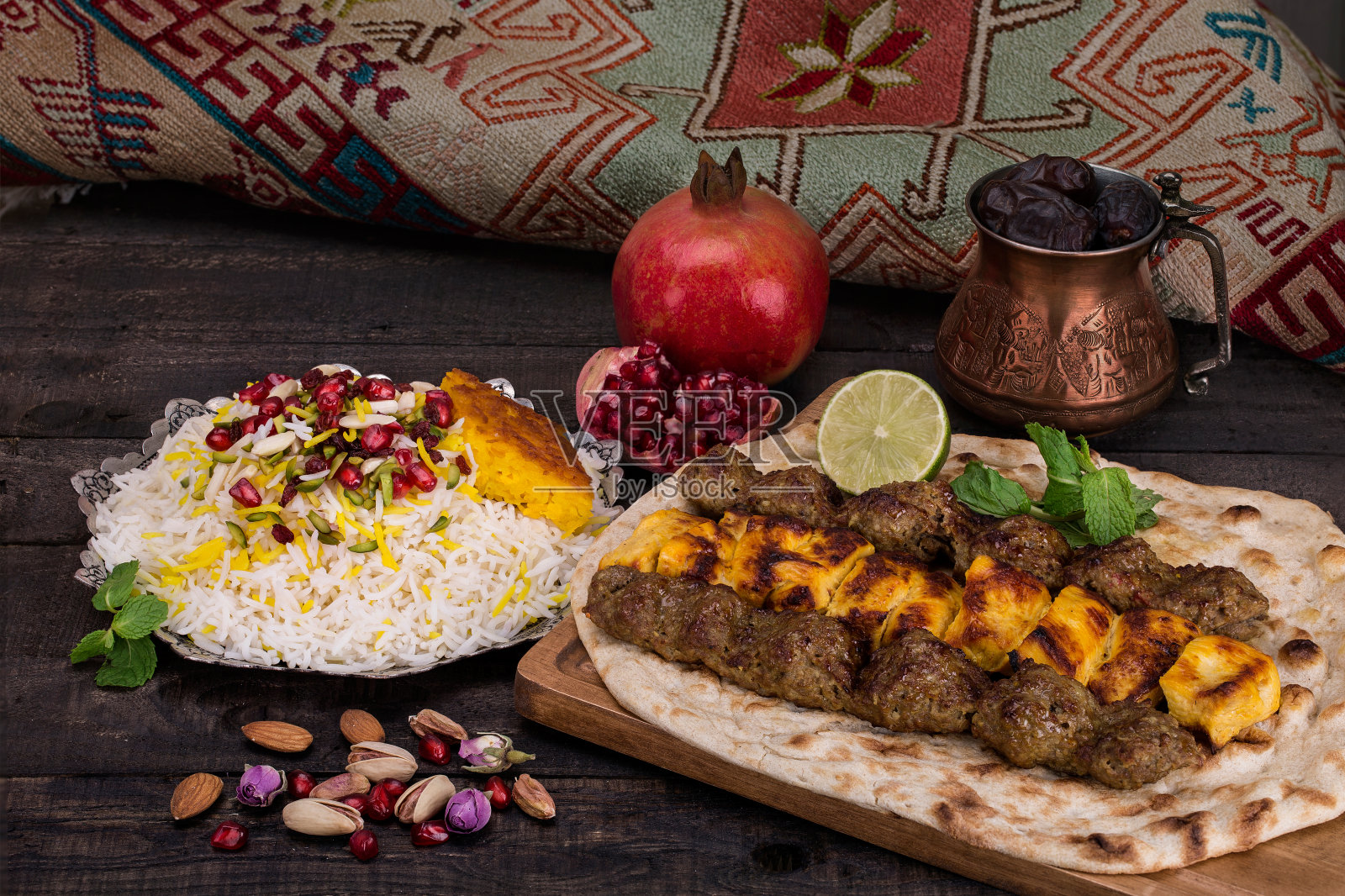 传统的中东波斯鸡肉和羊肉烤肉串(串肉)烧烤在平皮塔饼和藏红花米，塔奇恩和石榴在黑暗的背景。伊朗菜照片摄影图片