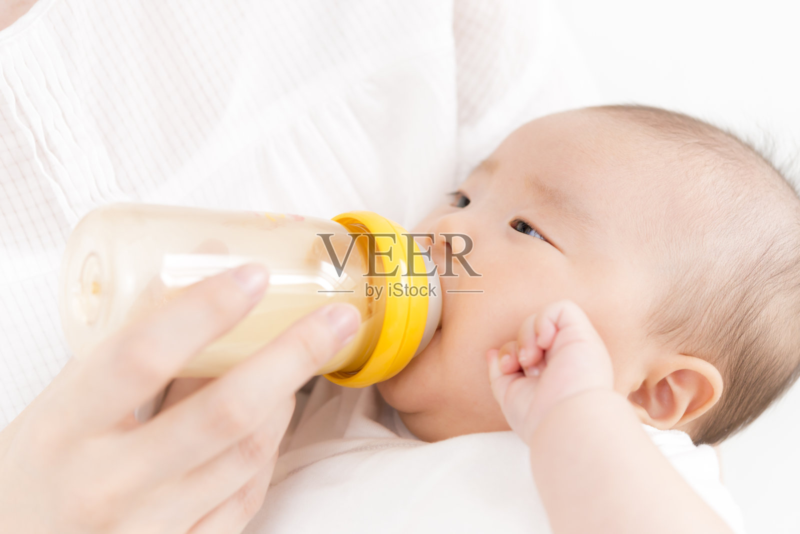 婴儿用奶瓶喝牛奶照片摄影图片
