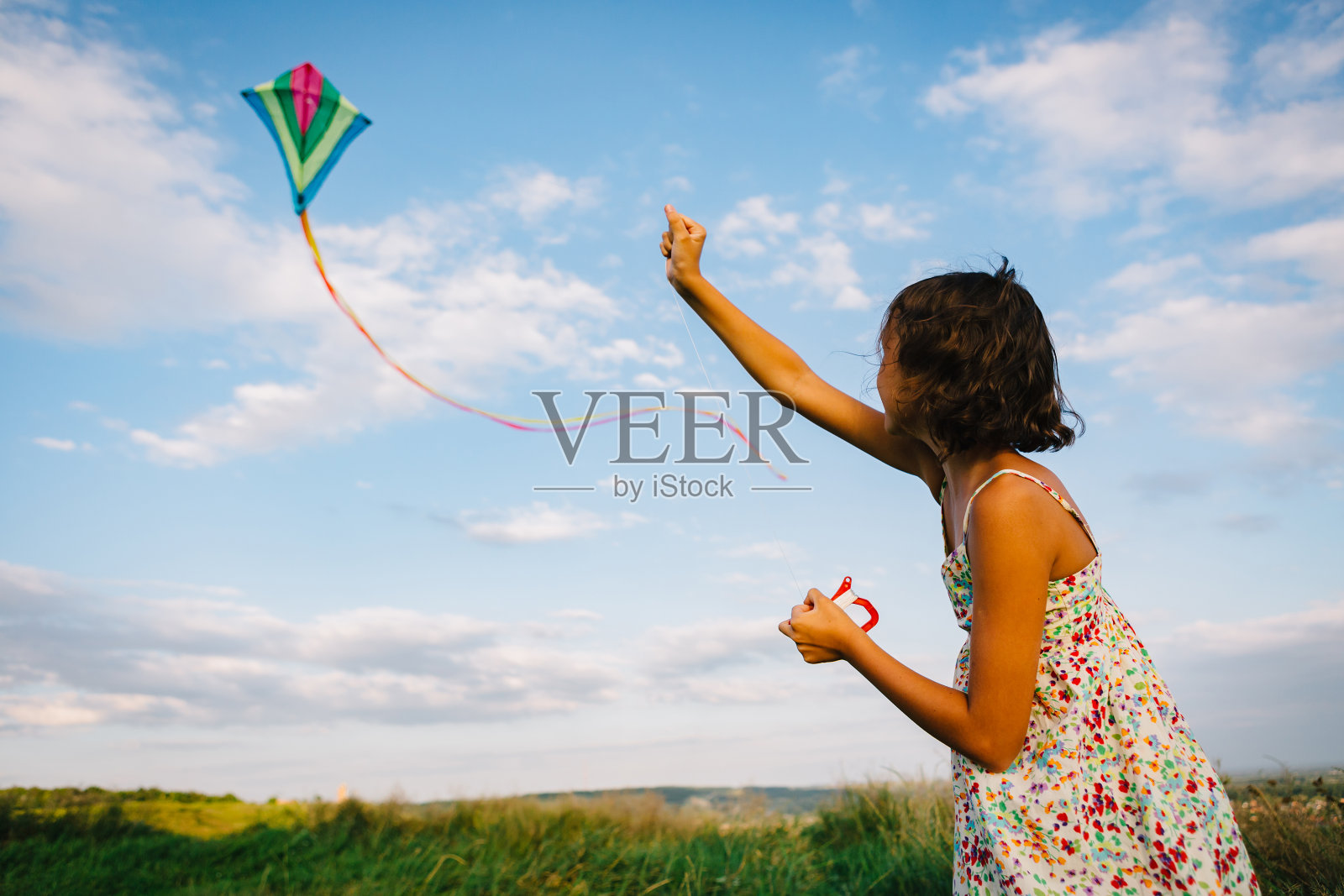 女孩在田野里玩风筝照片摄影图片