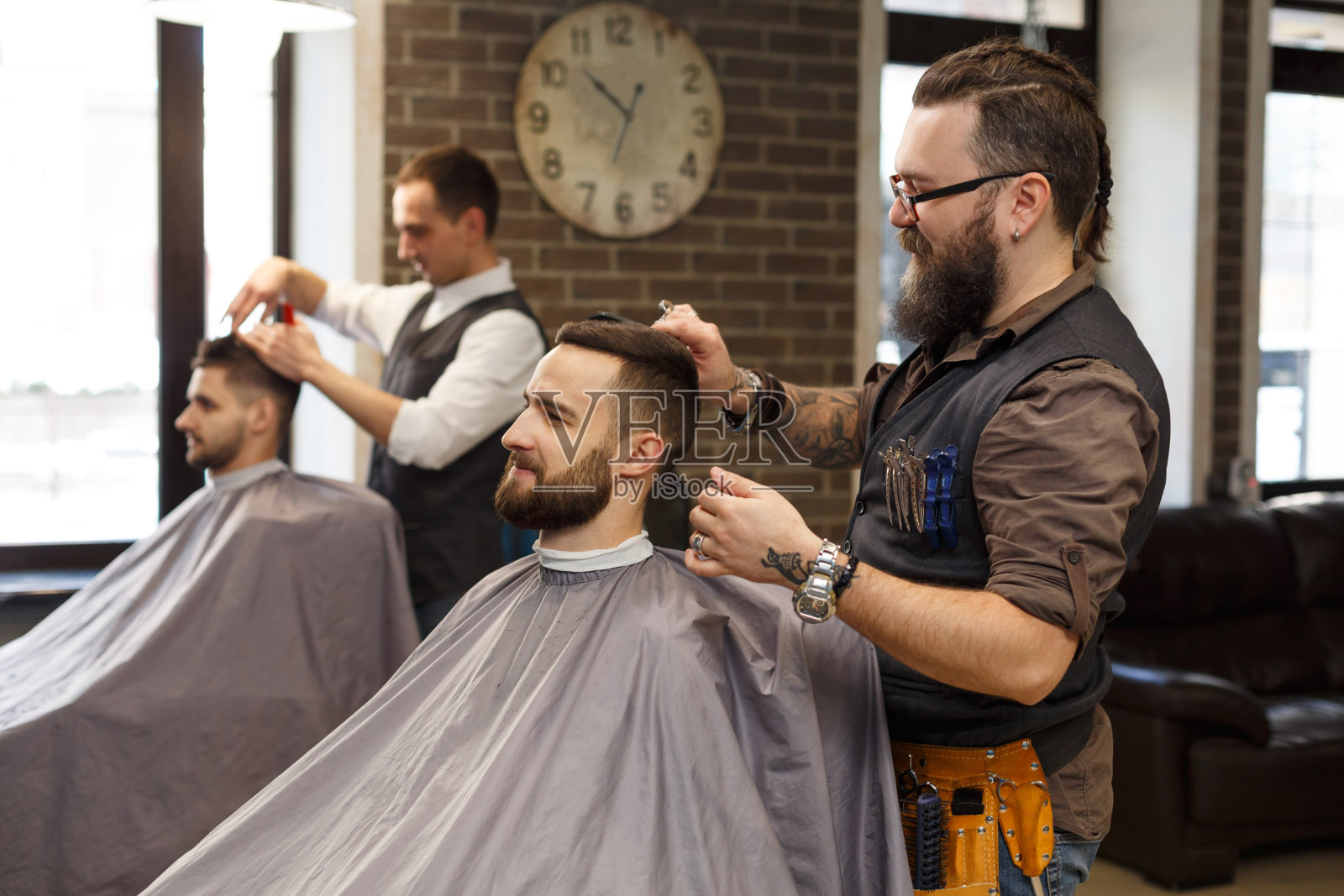 理发师在理发店用剪刀给顾客理发照片摄影图片