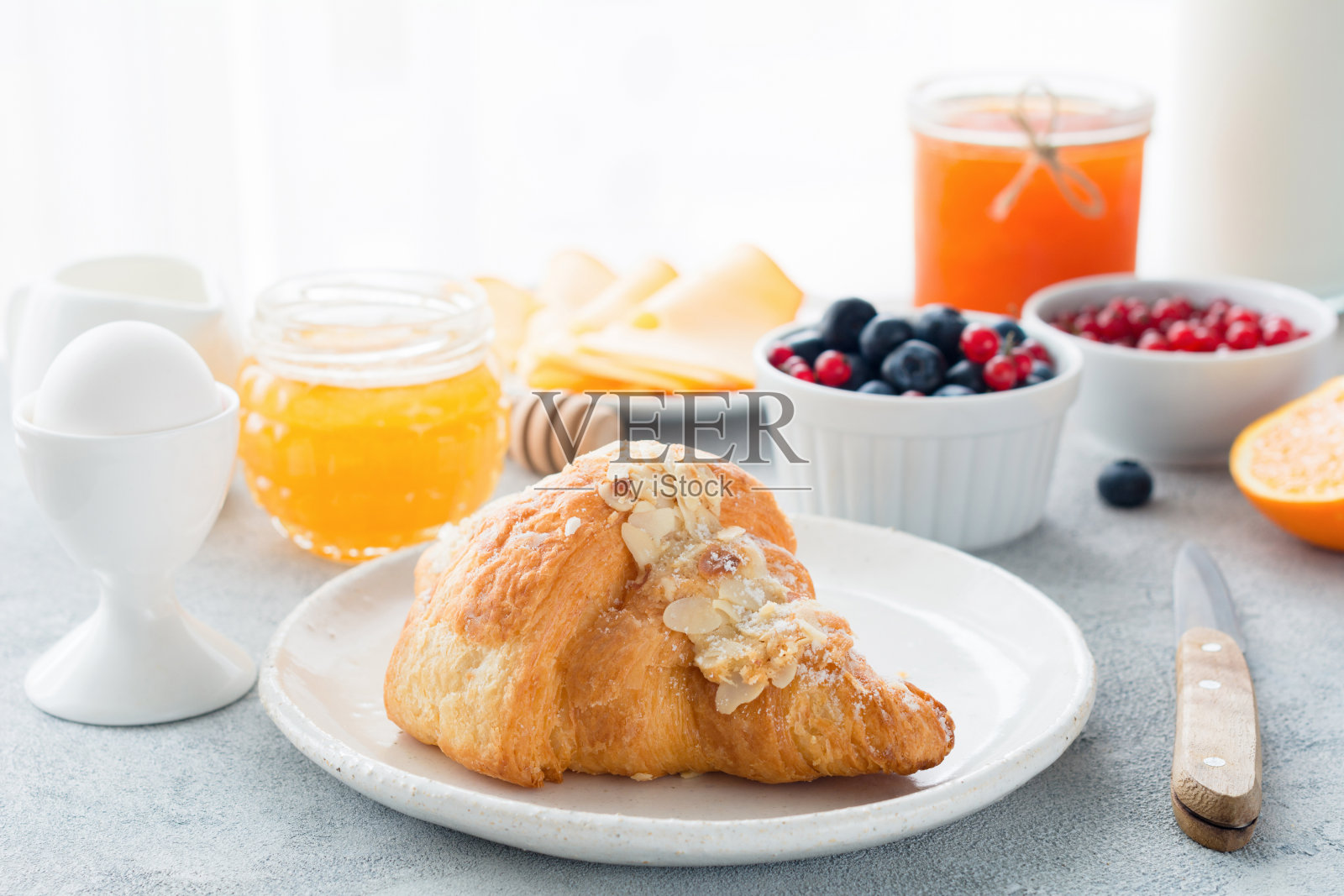 欧式早餐羊角面包，蜂蜜，果酱，浆果和鸡蛋照片摄影图片