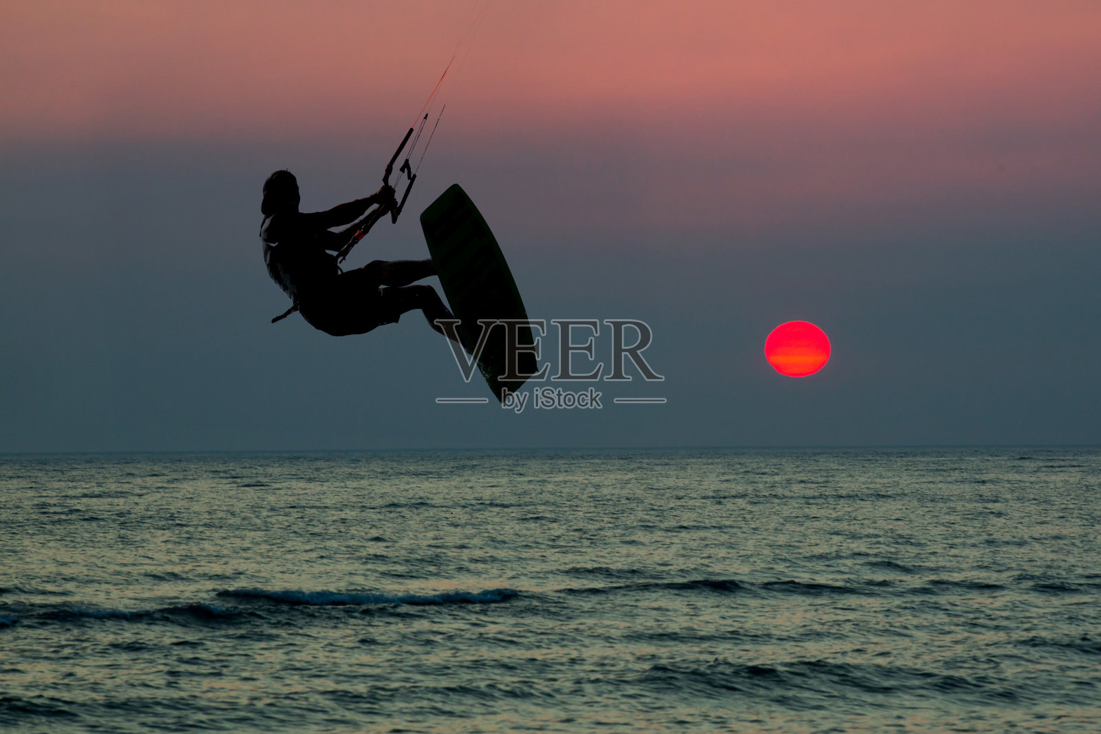 冲浪者在夕阳下跳跃照片摄影图片