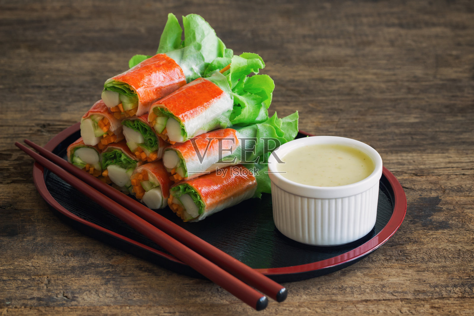 新鲜的春卷，新鲜的蔬菜，蟹肉条，芥末混合沙拉奶油蘸酱。日式沙拉卷或新鲜春卷，健康美味的开胃菜或正餐。照片摄影图片
