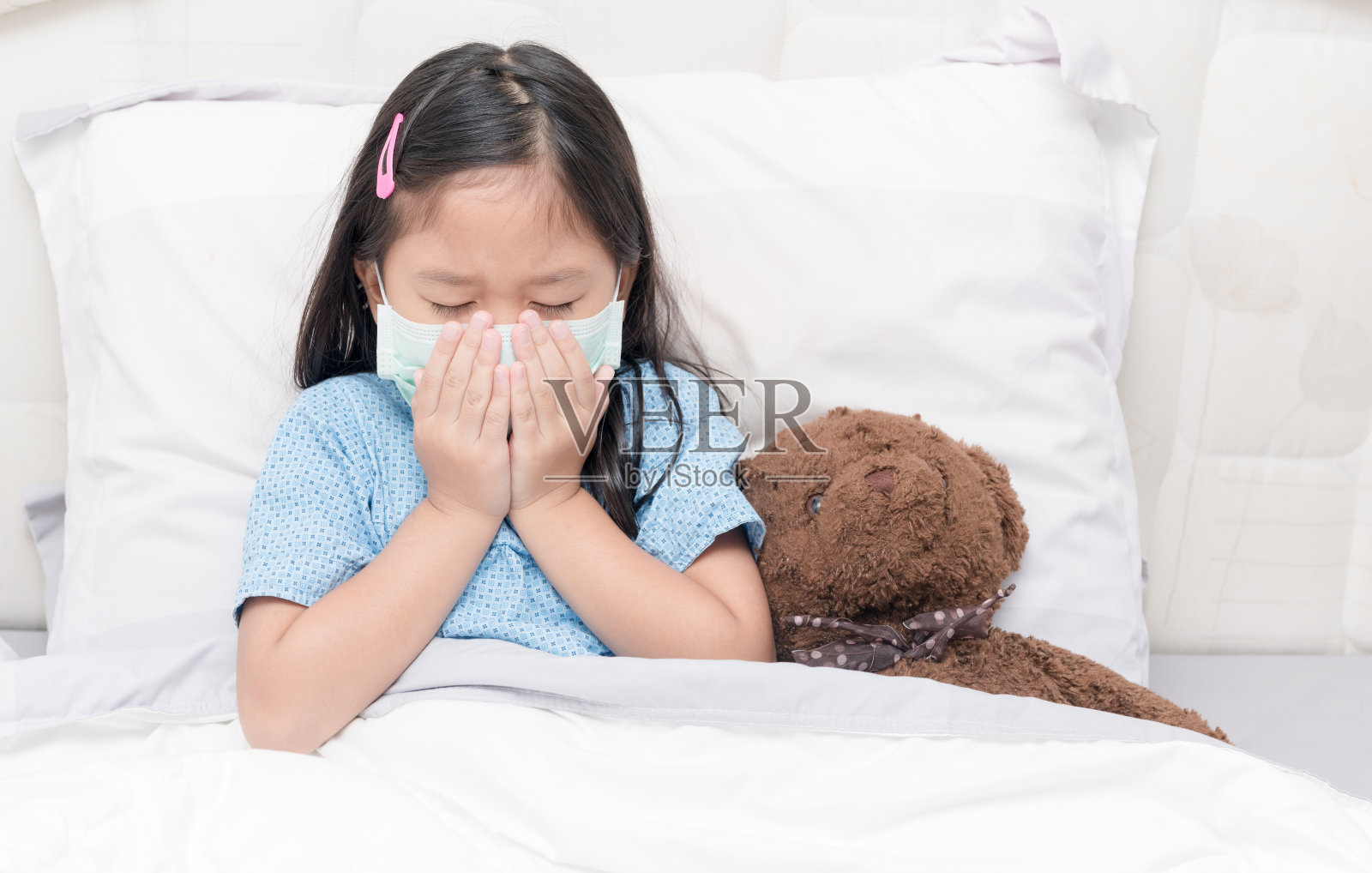 亚洲小女孩咳嗽和水卫生口罩。照片摄影图片
