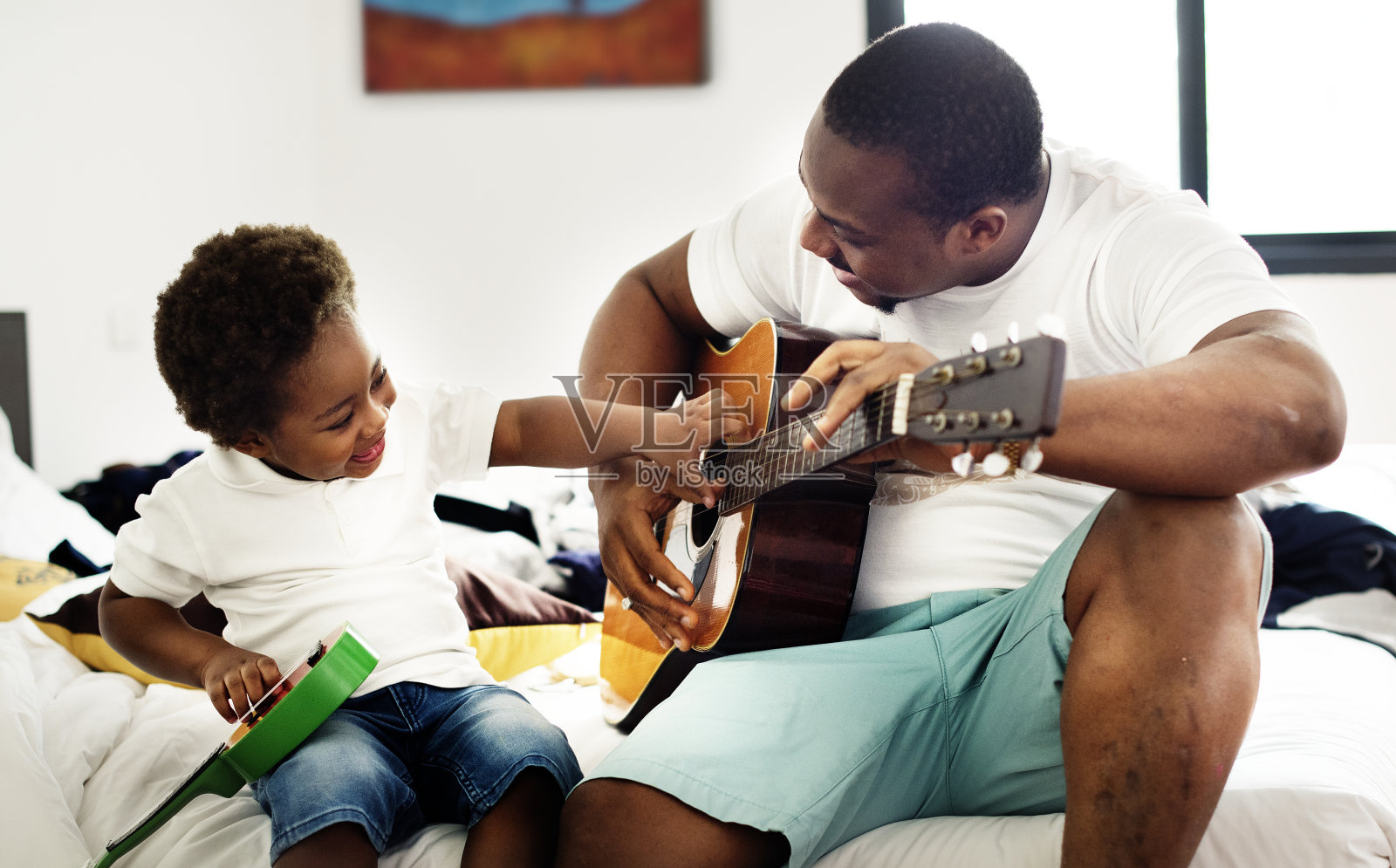 黑人父亲喜欢和他的孩子一起弹吉他，快乐无比照片摄影图片