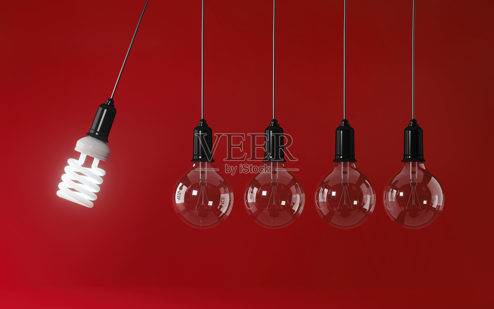 在红色背景上永久运动的节能灯泡:能源效率概念照片摄影图片