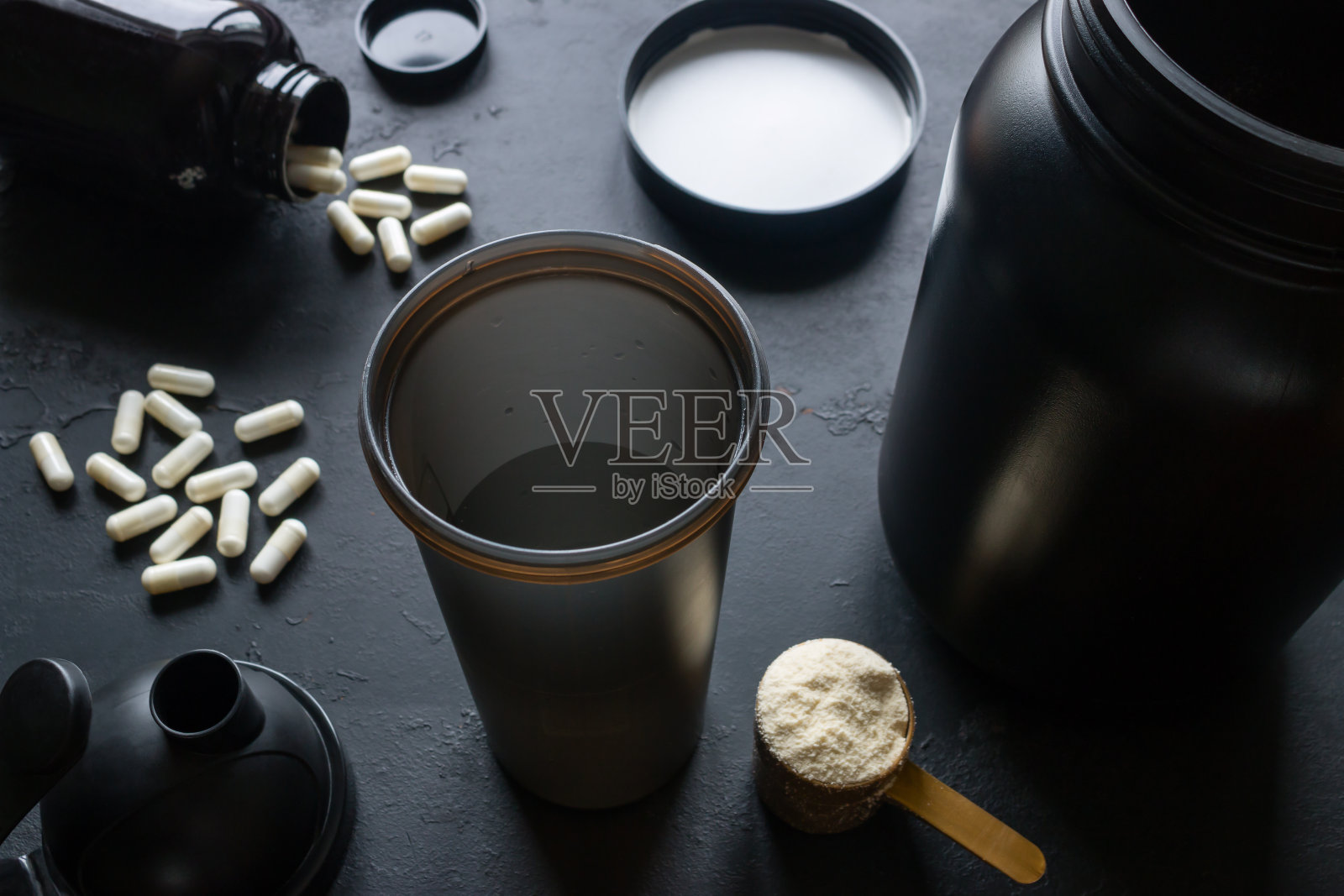 摇瓶，蛋白质，肌酸和其他运动补充剂在黑色背景照片摄影图片