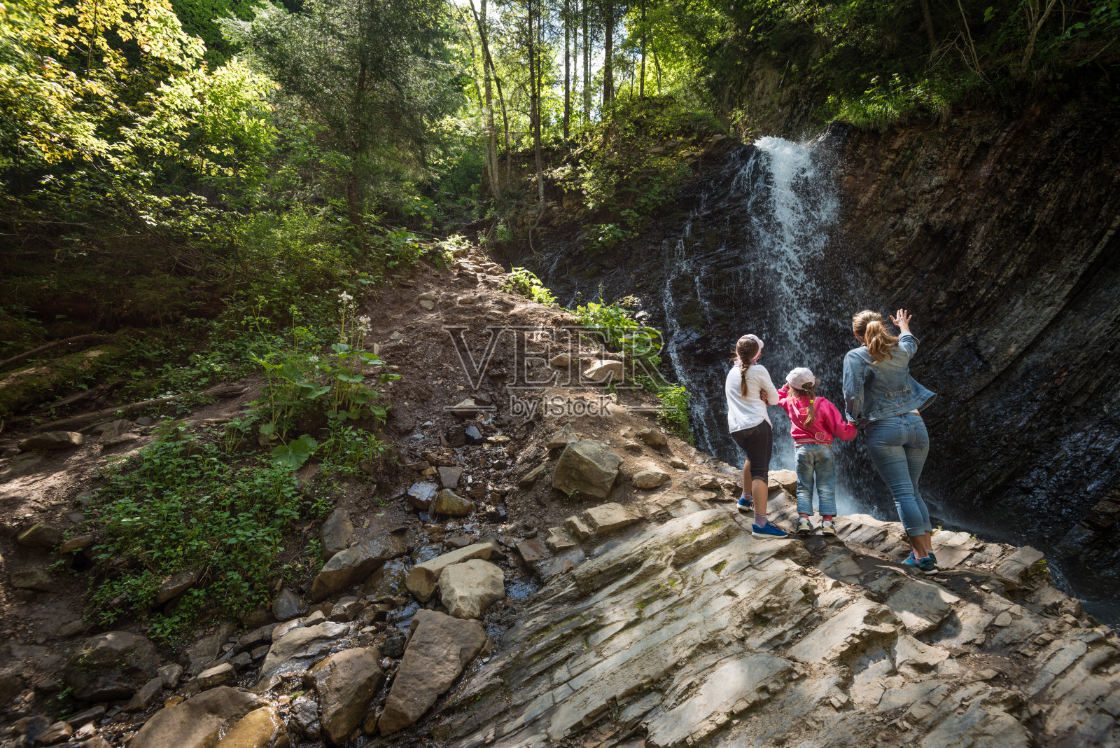 一家人在瀑布附近放松照片摄影图片