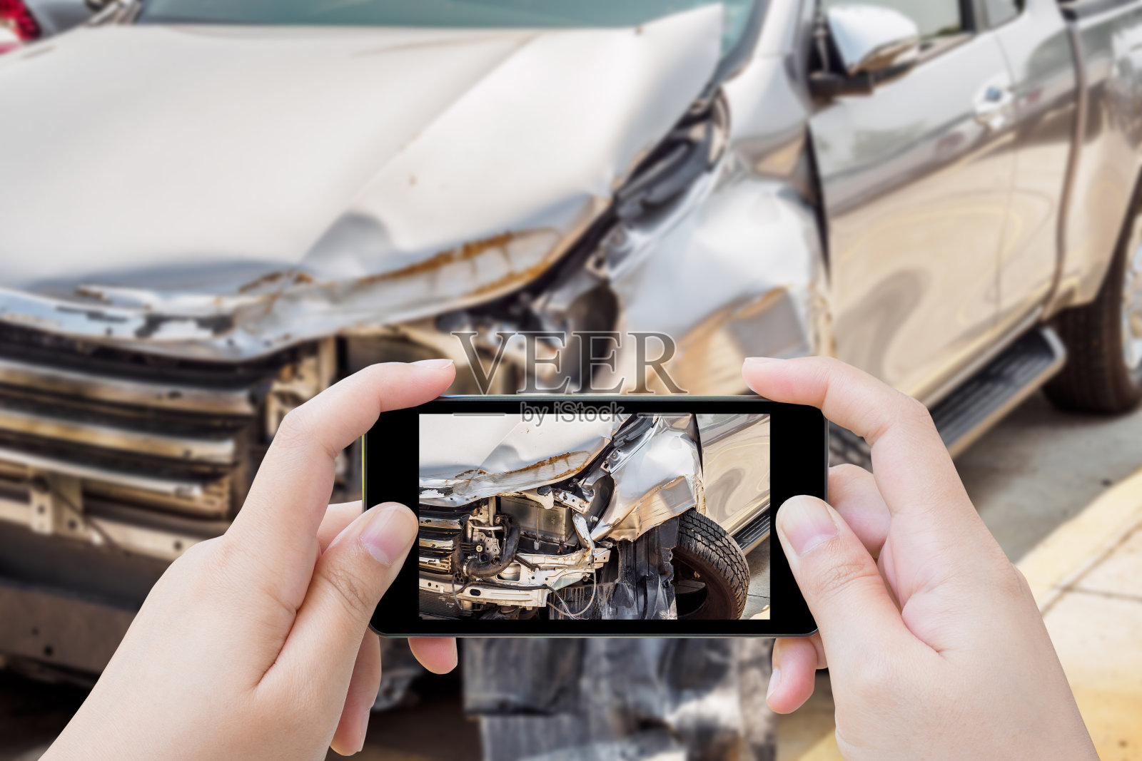 一名女子用手机拍下因车祸而损坏的保险照片照片摄影图片