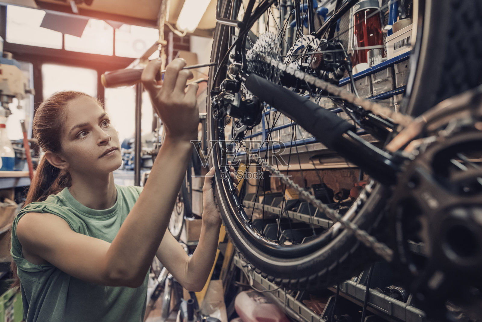 女自行车修理工正在车间里修一辆自行车照片摄影图片