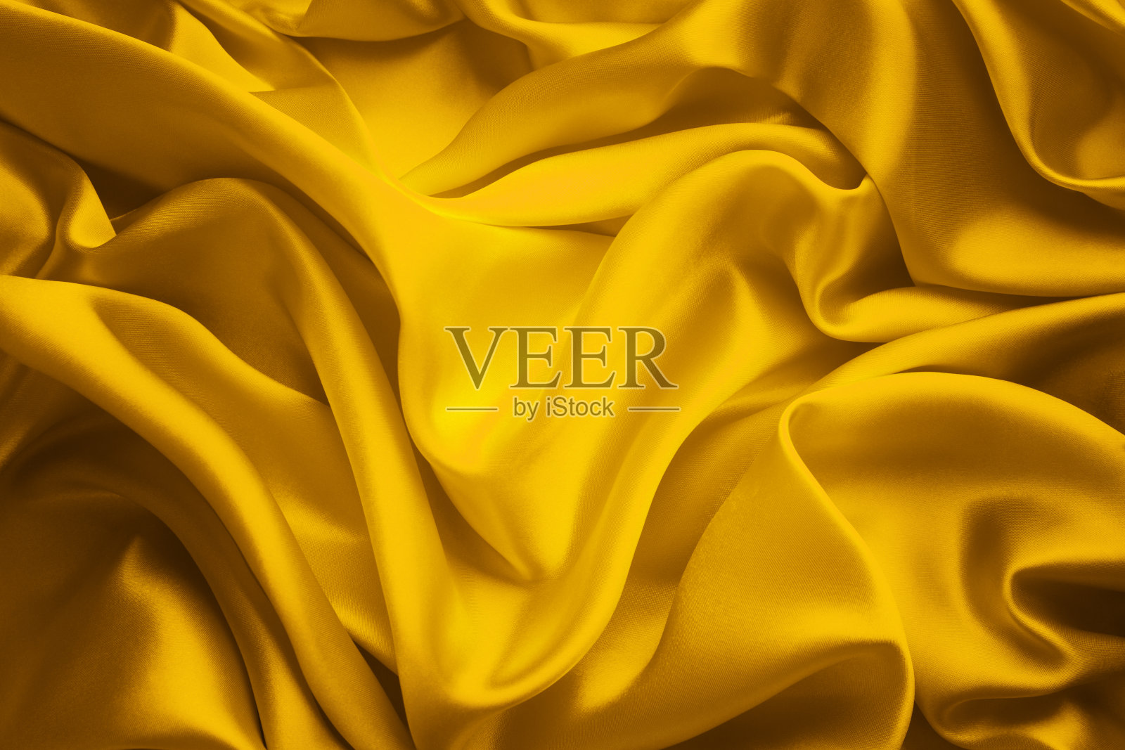 丝绸面料背景，黄缎布波浪，抽象的流动波浪纺织品照片摄影图片