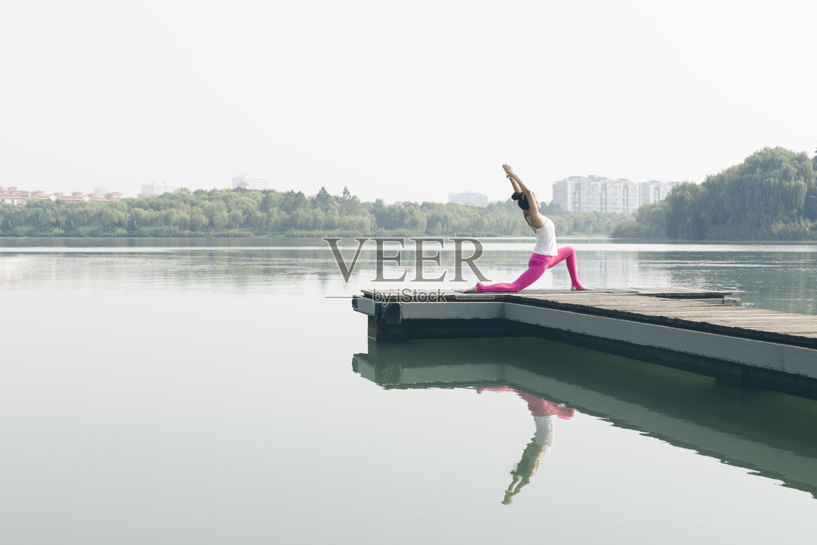 年轻女子在湖边码头做瑜伽照片摄影图片