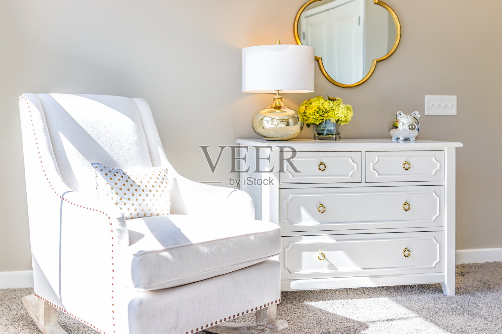 明亮的白色现代摇椅在婴儿室与抽屉柜，装饰在模型分期家，公寓或房子照片摄影图片