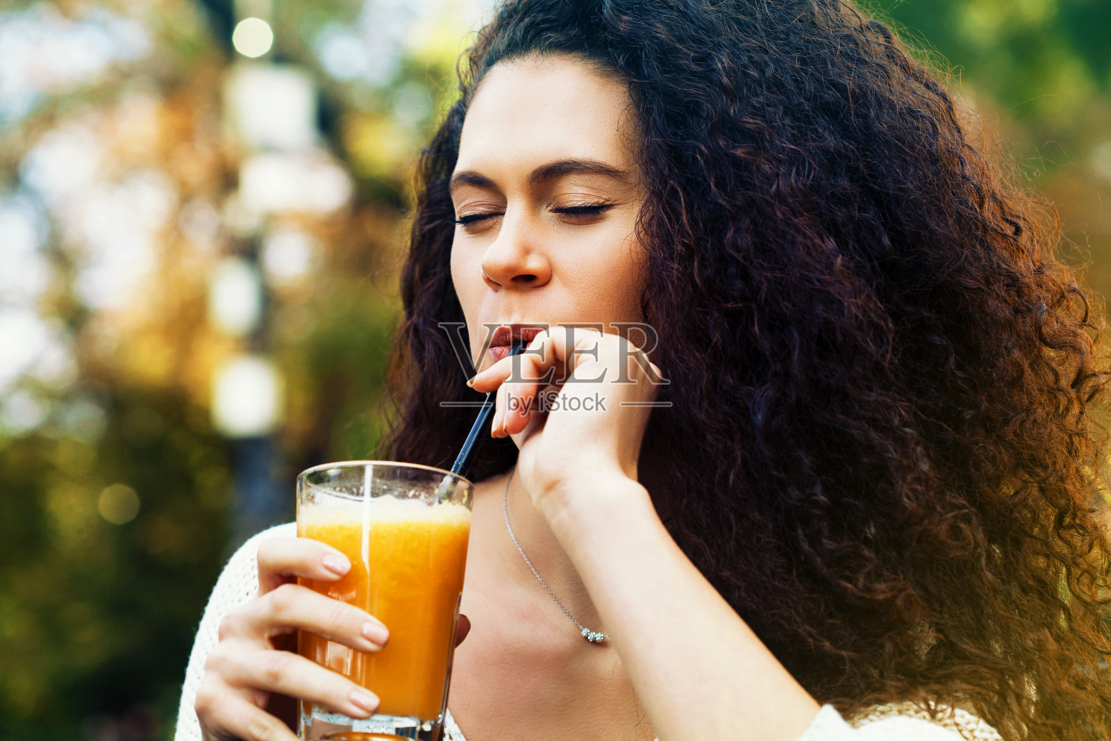 年轻女子喝橙汁照片摄影图片