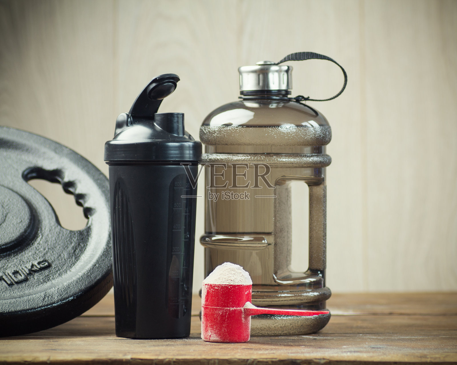 一勺蛋白质粉，是高强度锻炼后肌肉恢复的必要营养，旁边放着蛋白质调酒器照片摄影图片