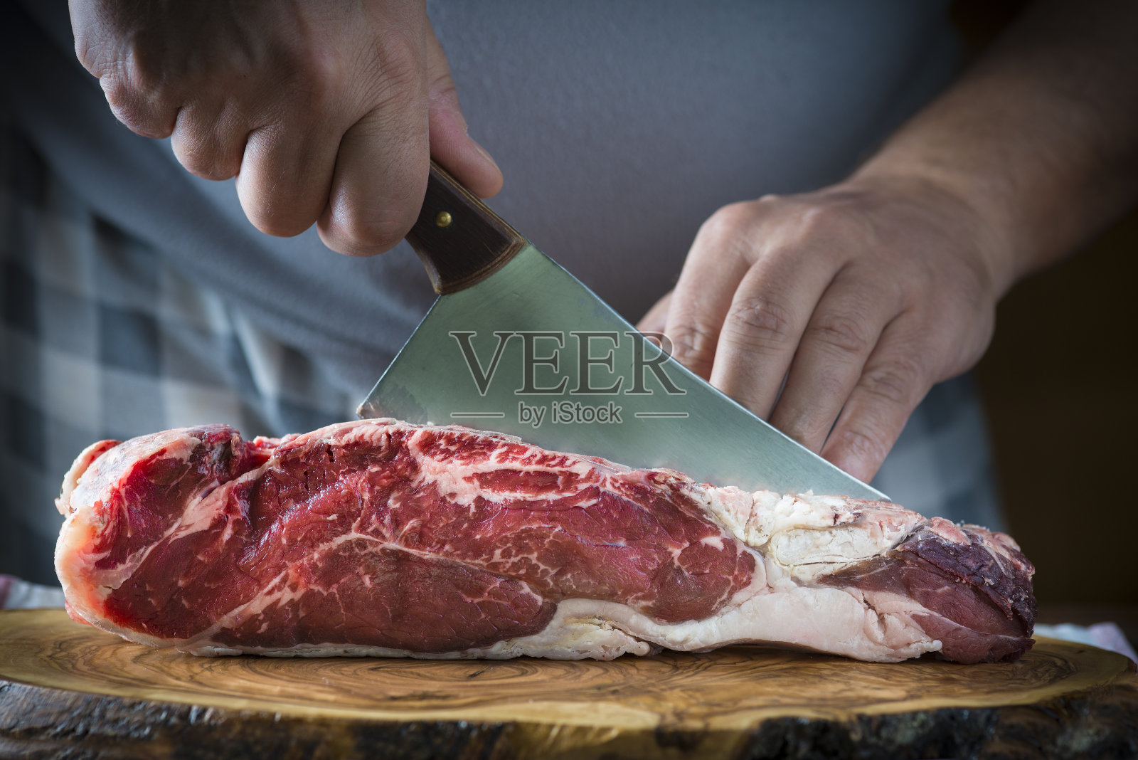 屠夫用切肉刀切肉照片摄影图片