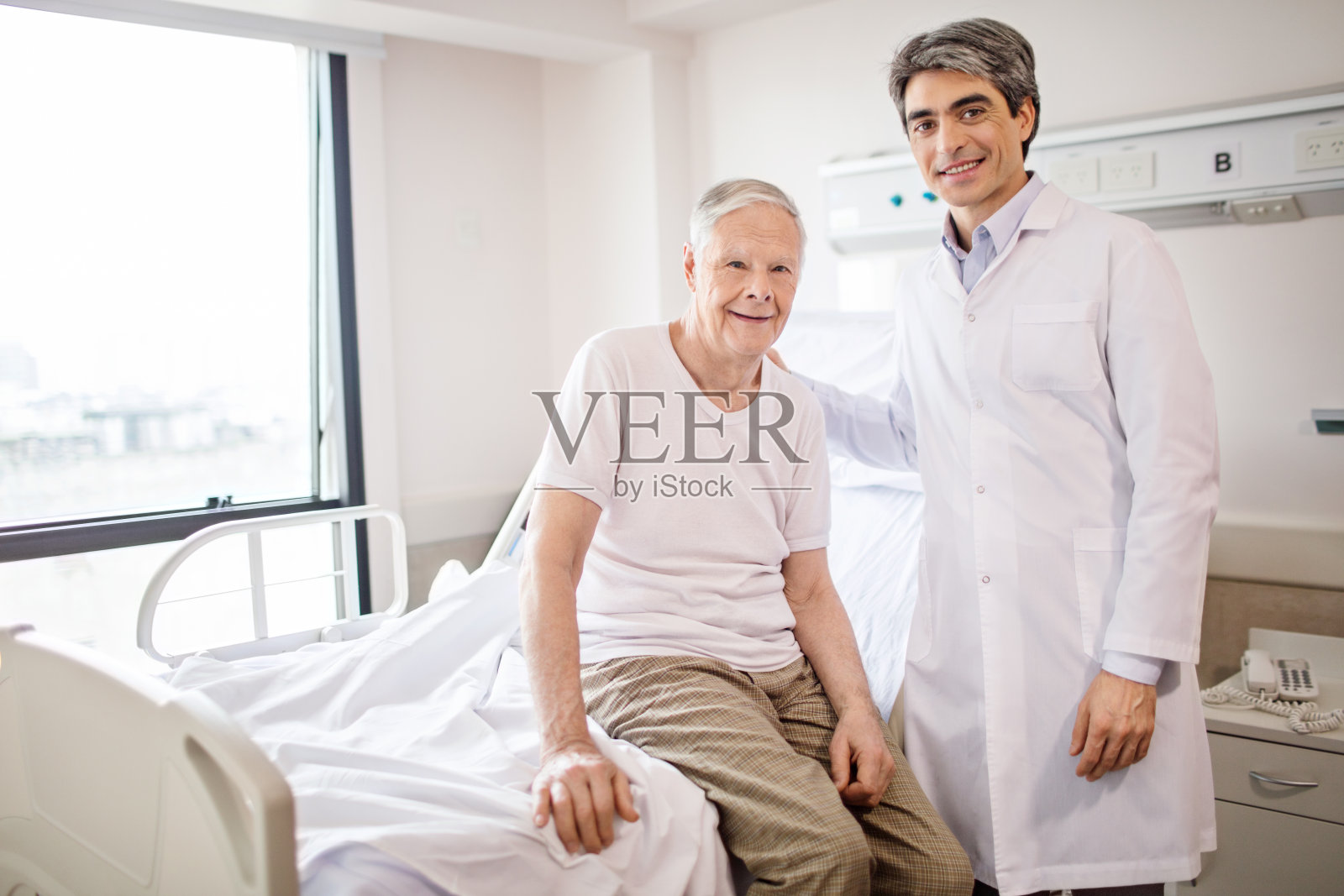 微笑的医生和老病人在医院照片摄影图片