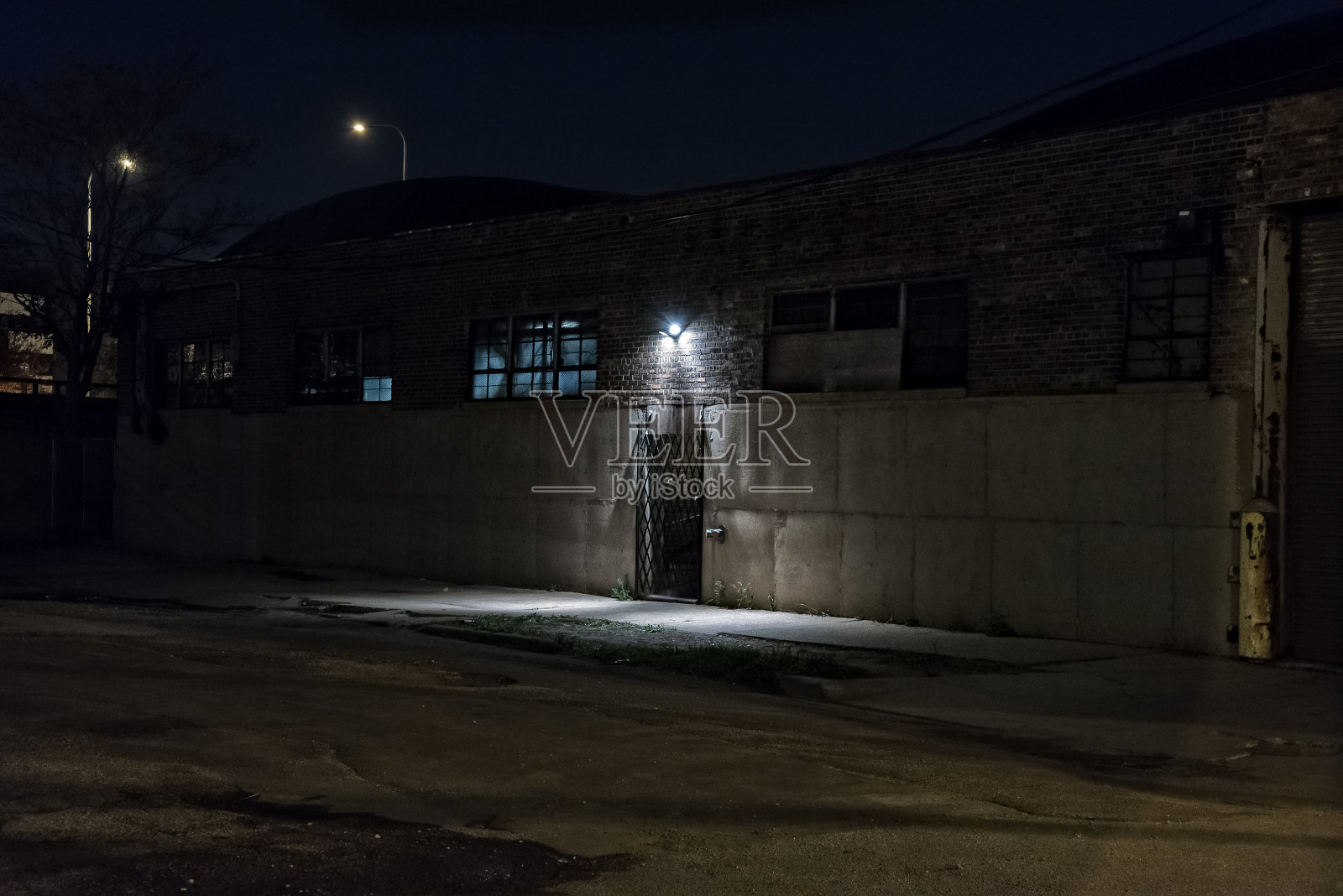 黑暗可怕的巷子在晚上与大门仓库入口。照片摄影图片