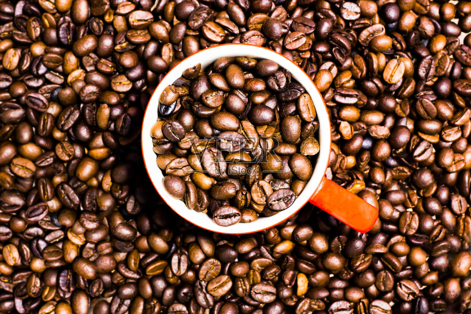 咖啡色背景的咖啡杯里的咖啡豆照片摄影图片